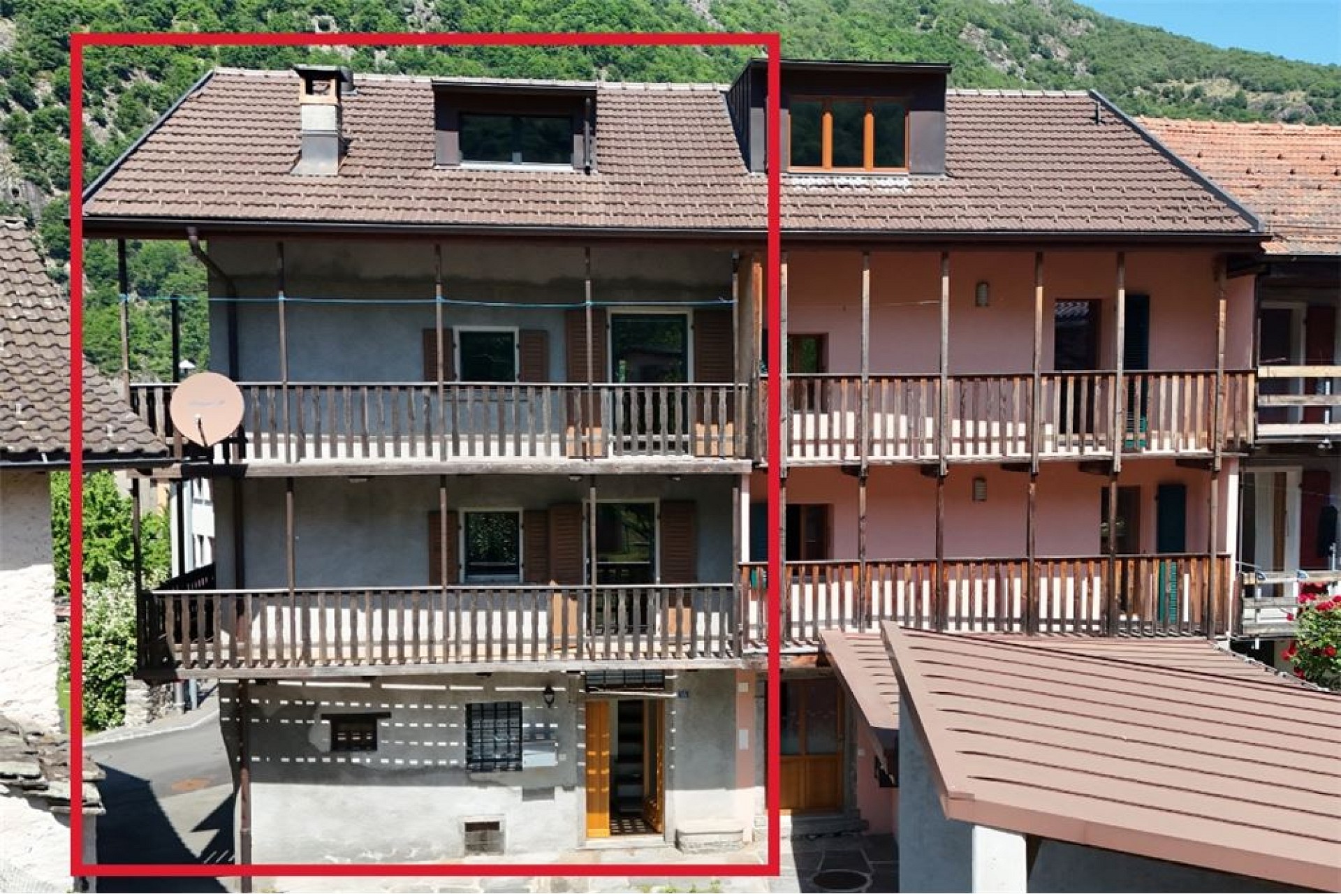 Wohnhaus mit Balkonen und bergigem Umfeld