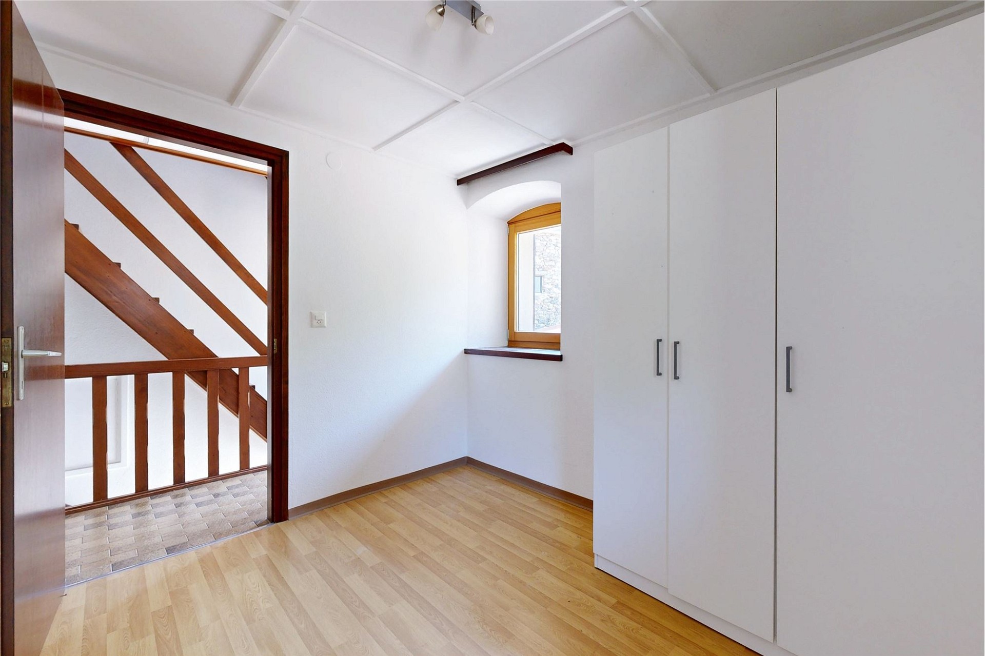 Heller Raum mit Dachschräge, Treppe und Einbauschrank