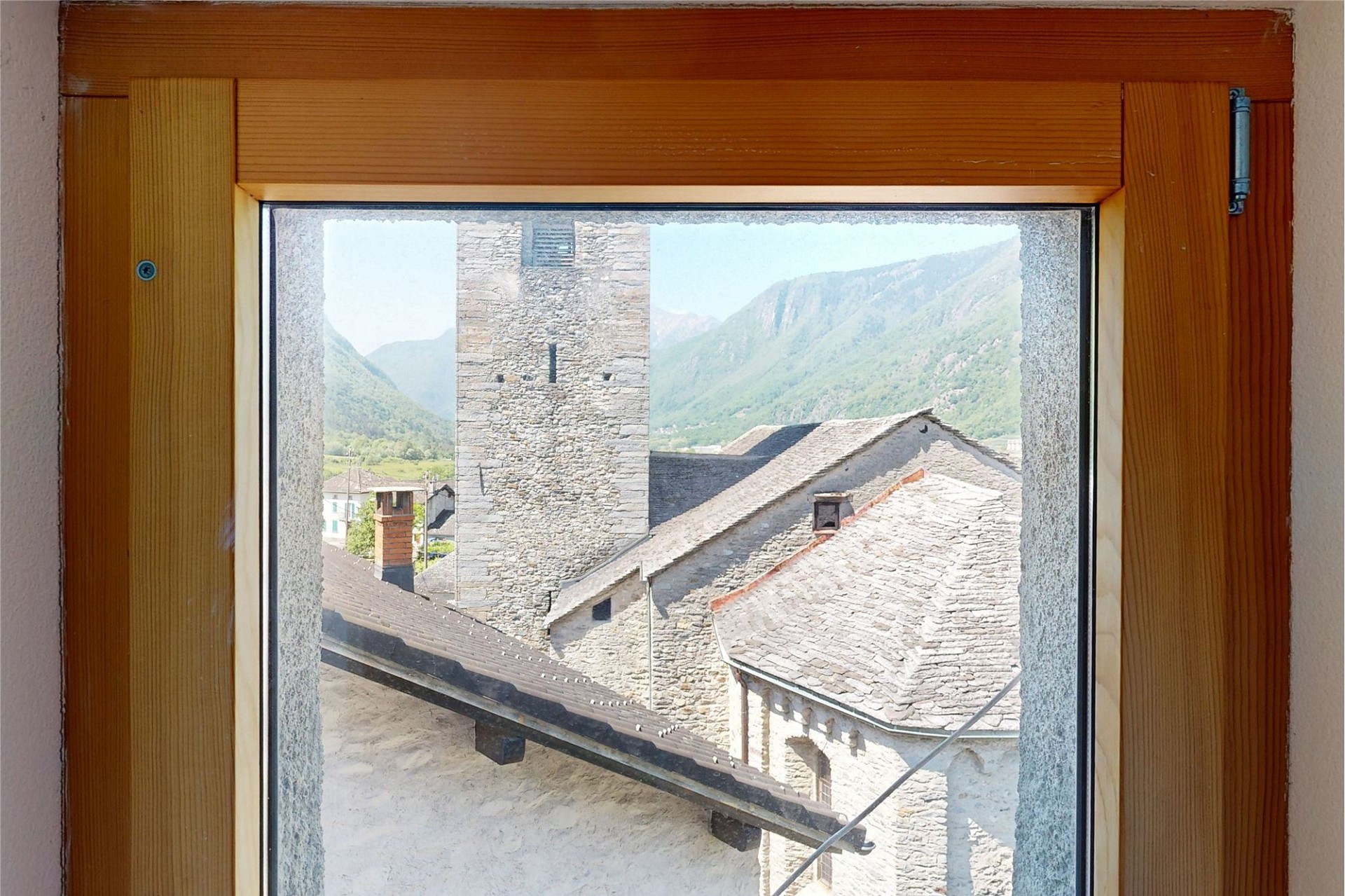 Fensterblick auf Bergdorf und Berge