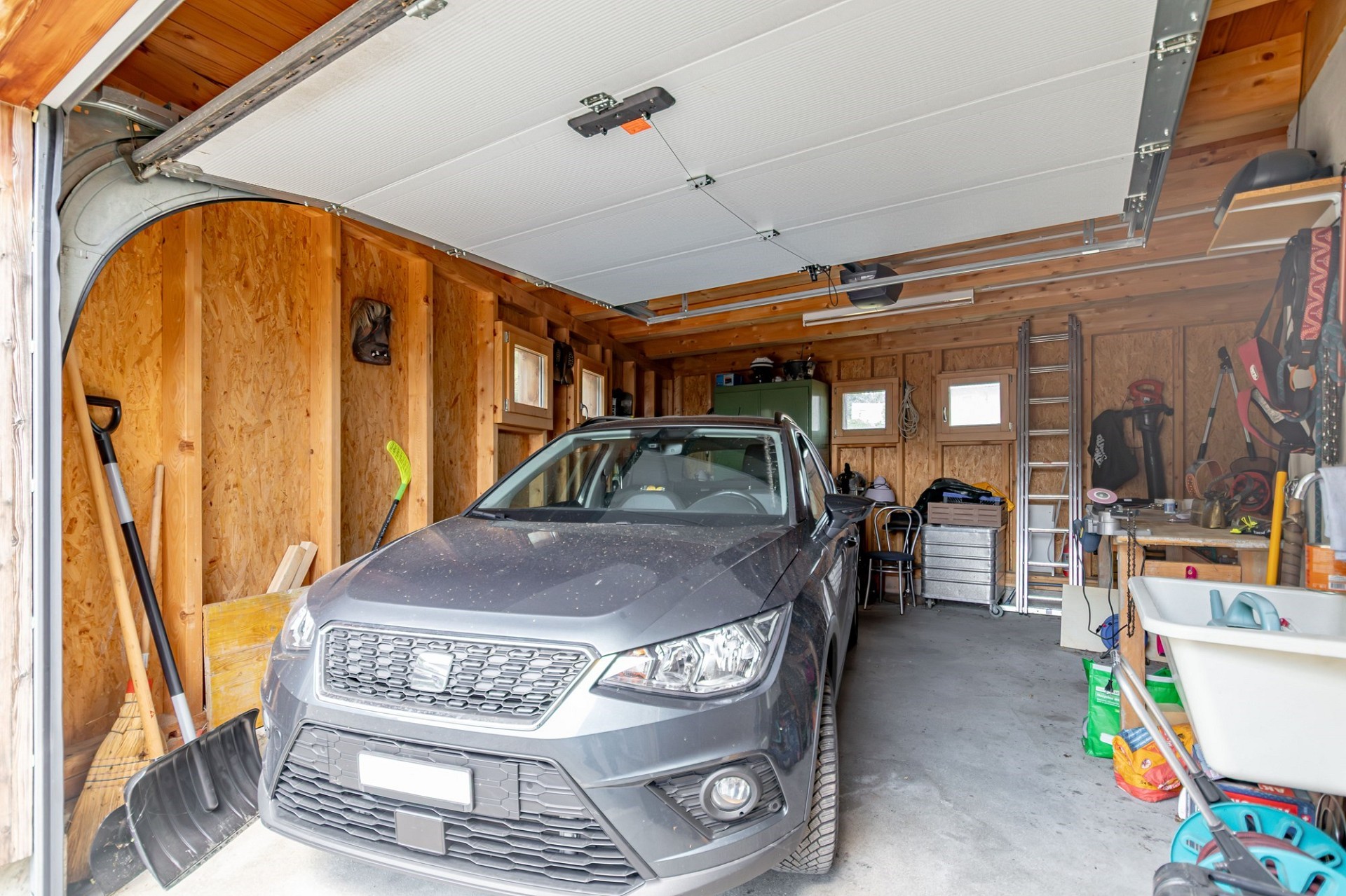 Garage mit geparktem Auto und viel Stauraum
