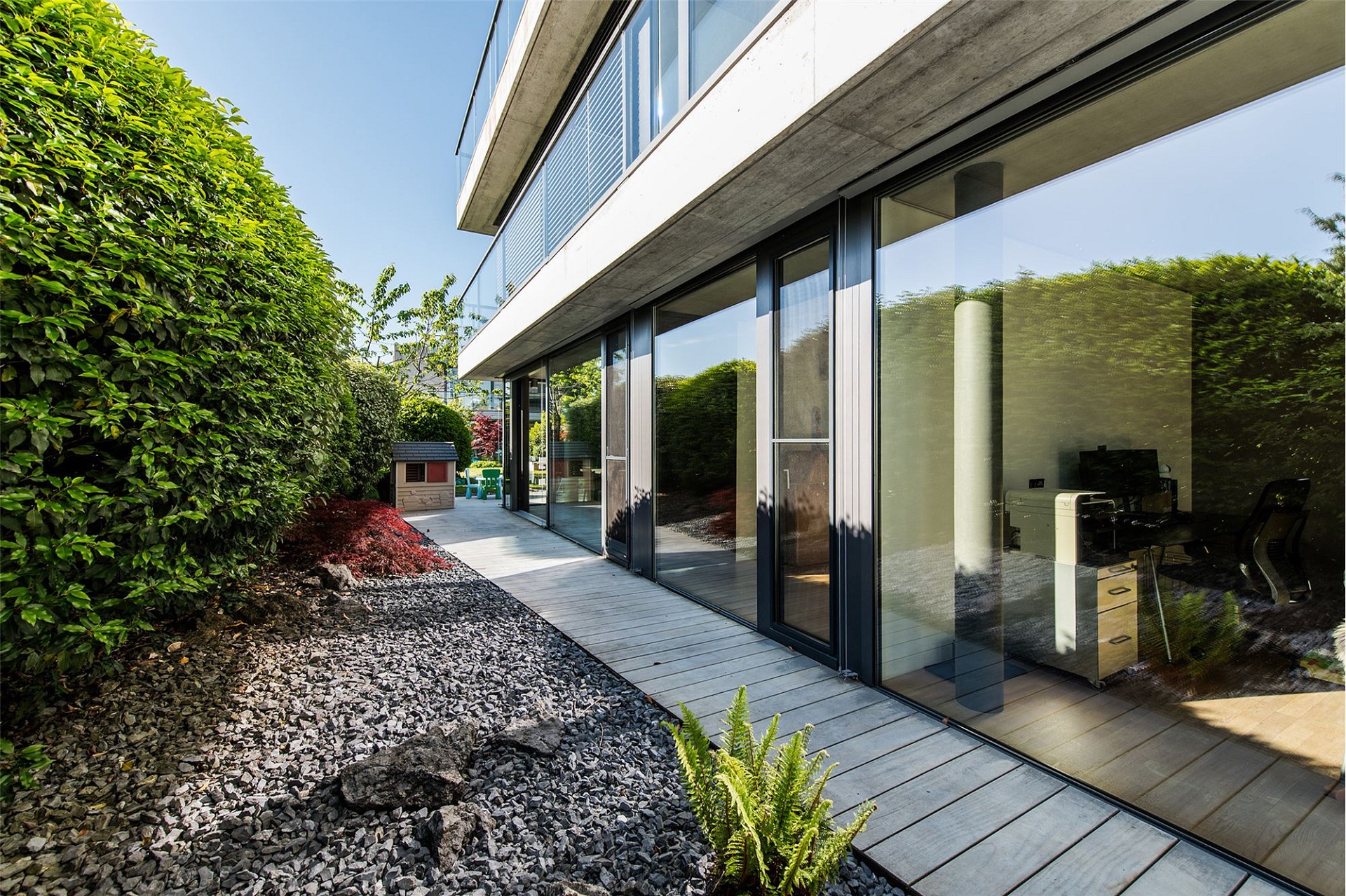 Moderne Außenansicht mit Garten und Glasfassade