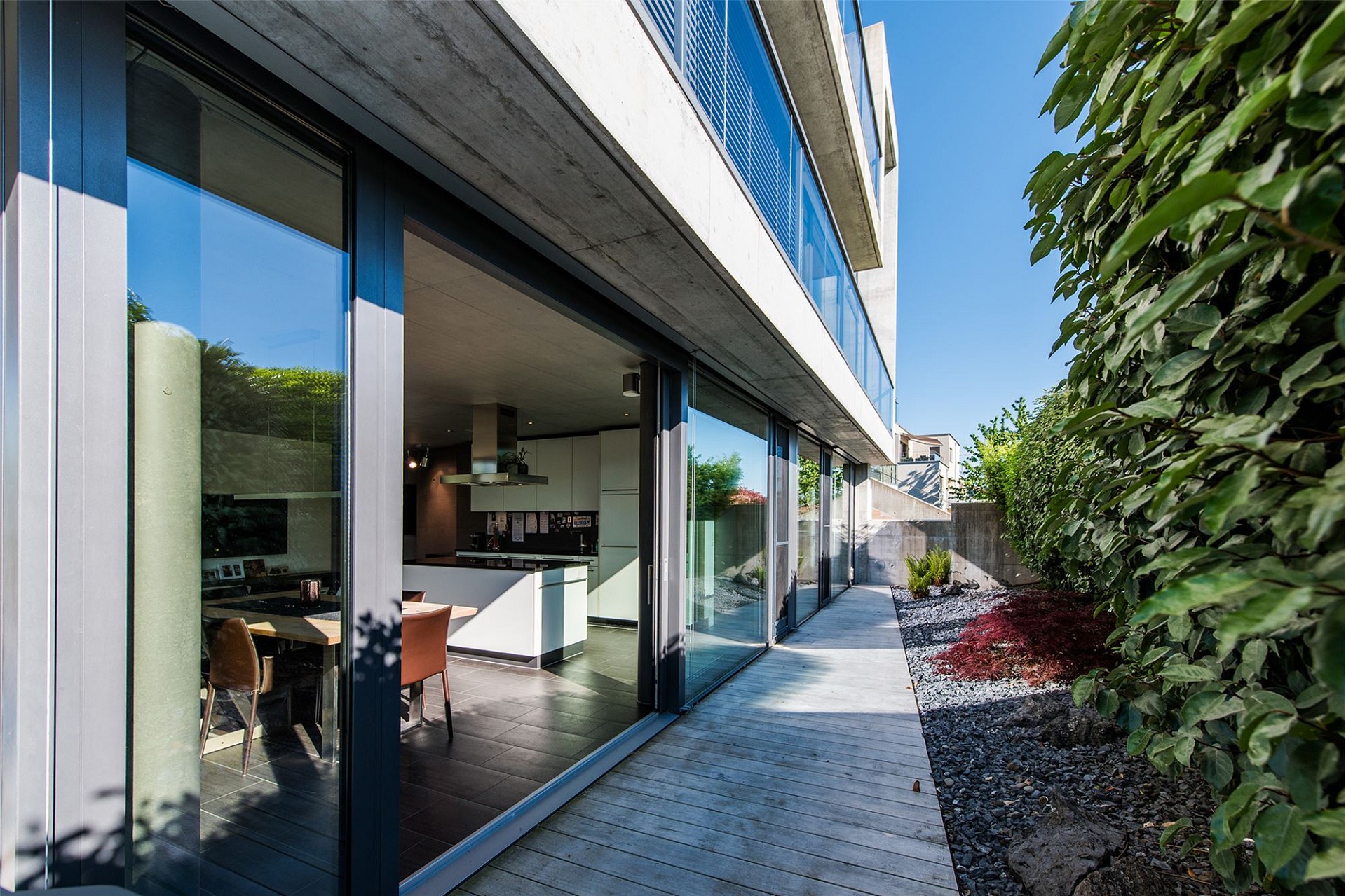 Moderne Außenansicht mit Glasfront und Gartenweg
