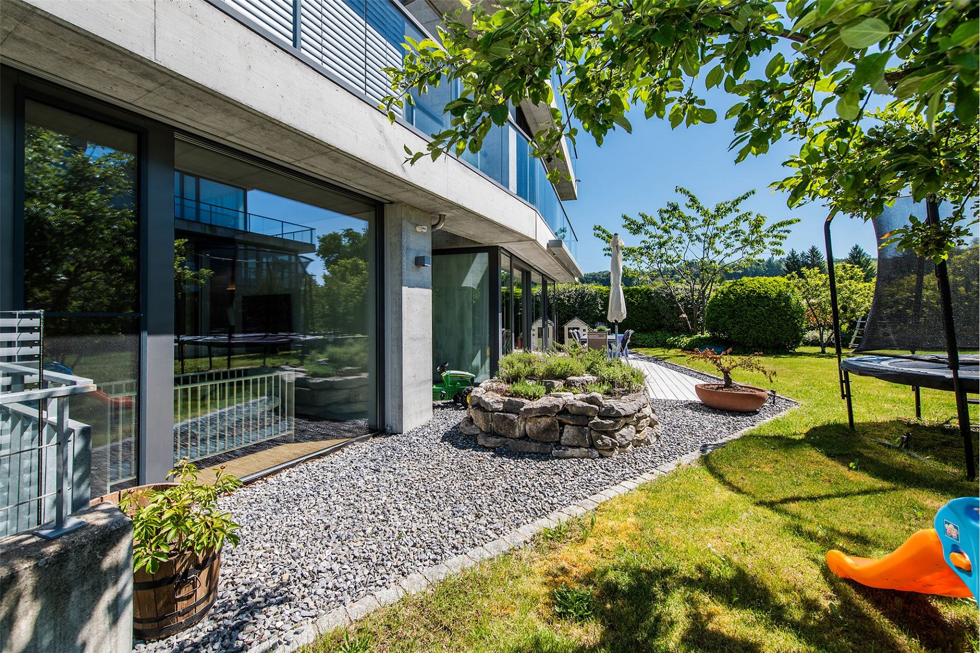 Moderner Garten mit Architektur aus Sichtbeton und Glas