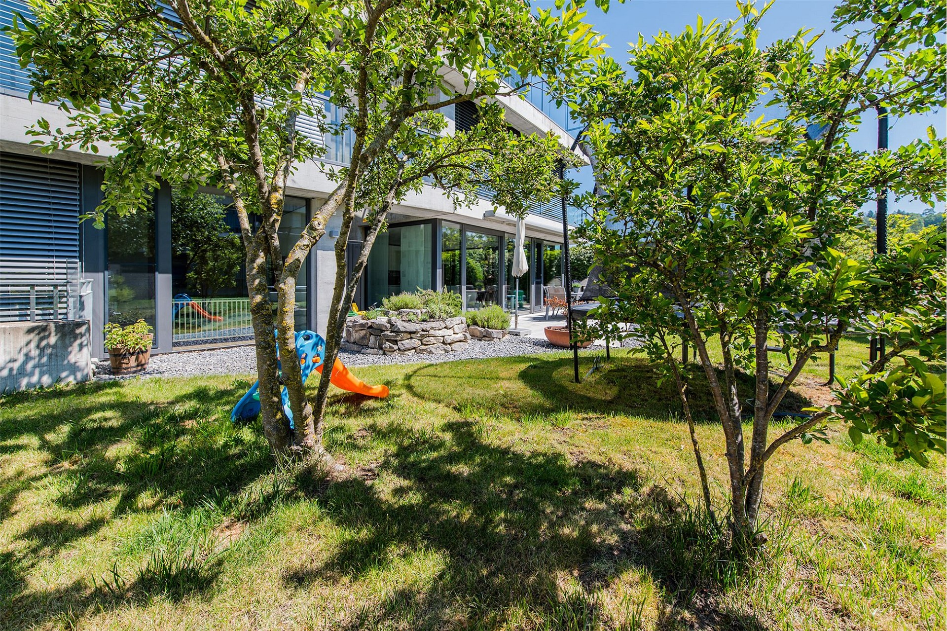 Moderner Garten mit Terrasse und Spielbereich