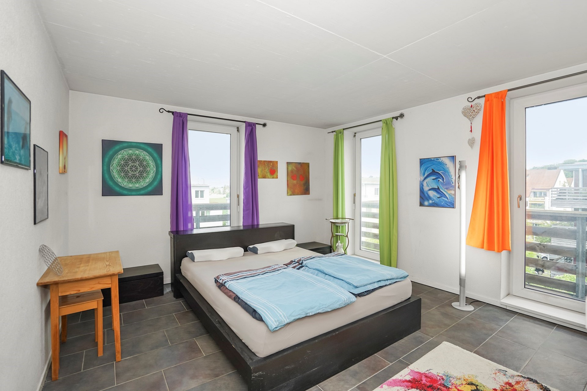 Helles Schlafzimmer mit farbigen Vorhängen