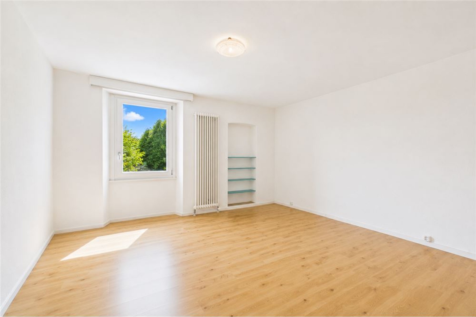 Heller leerer Raum mit Fenster und Holzboden