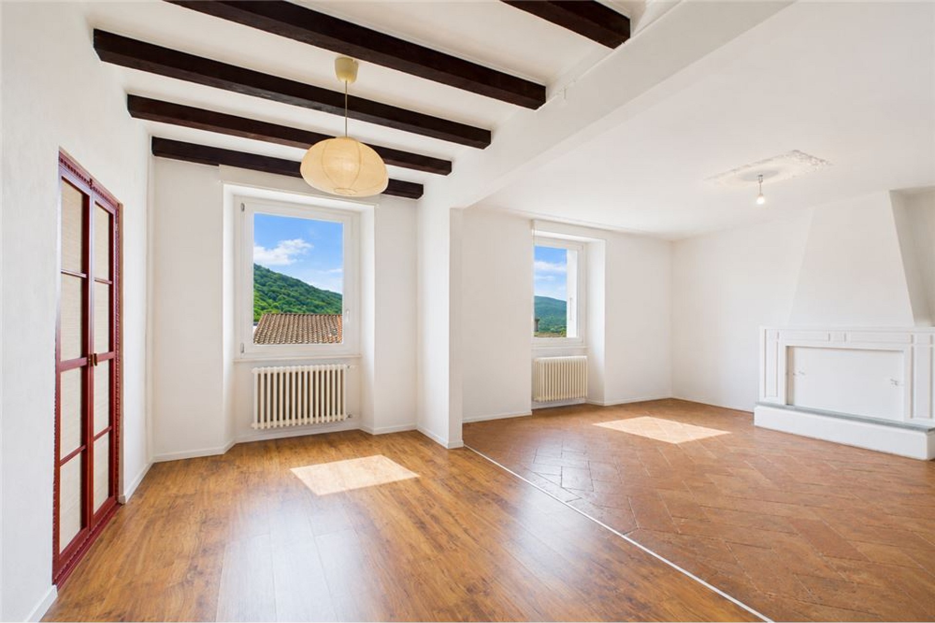 Heller leerer Wohnraum mit Holzbalkendecke