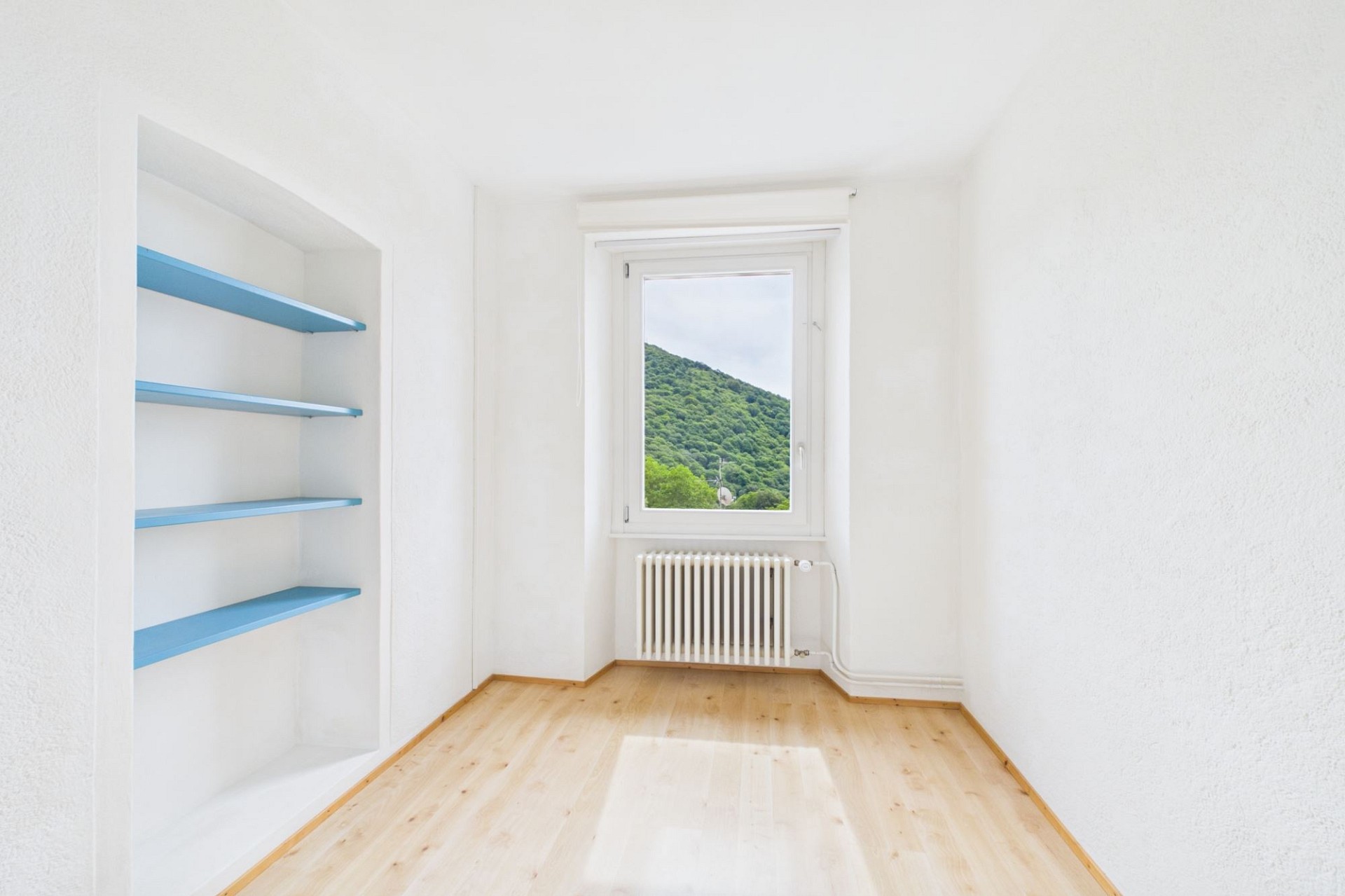 Heller leerer Raum mit Fenster und Einbauregal