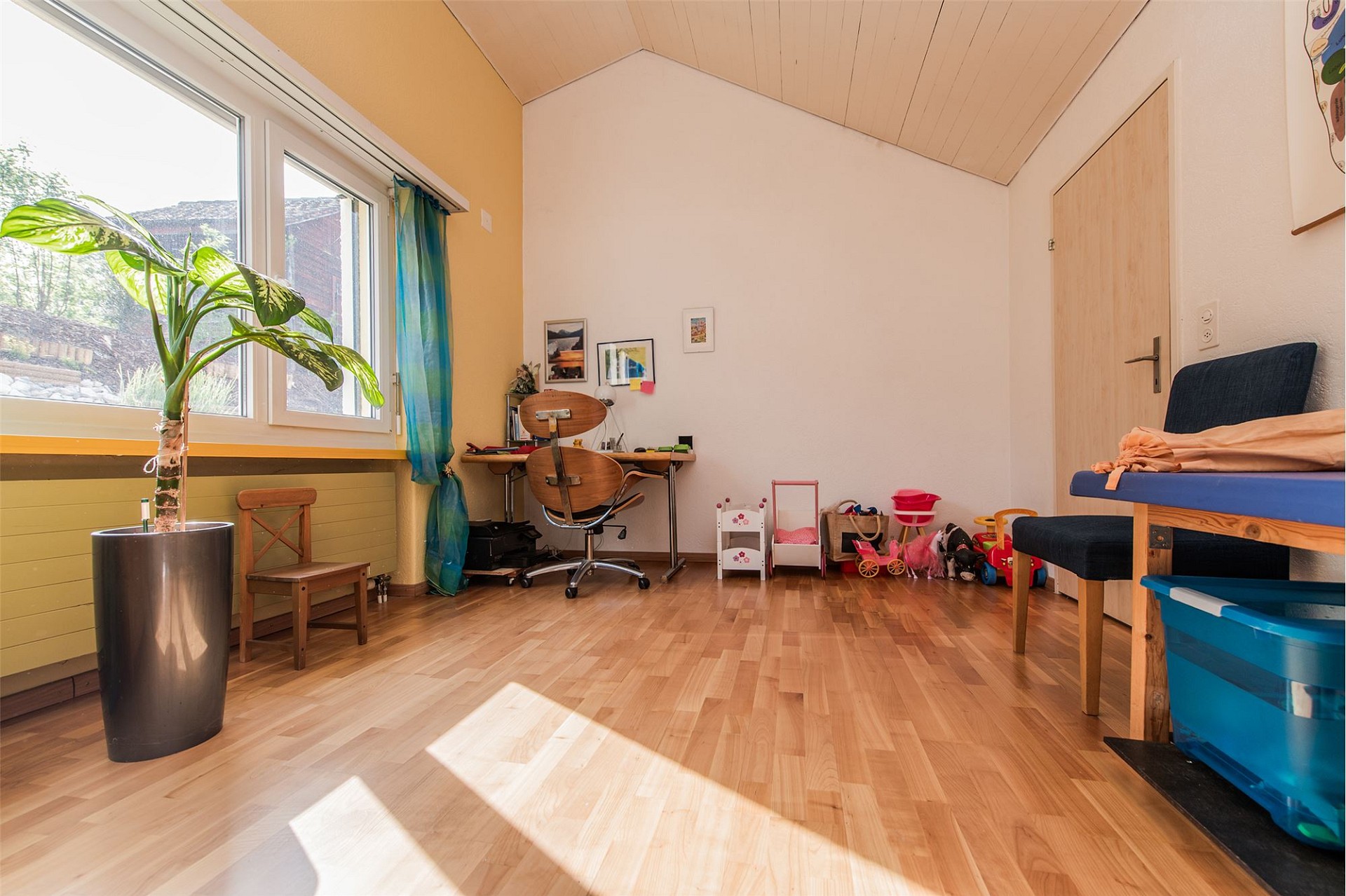 Helles Dachzimmer mit Arbeitsbereich und Spielbereich