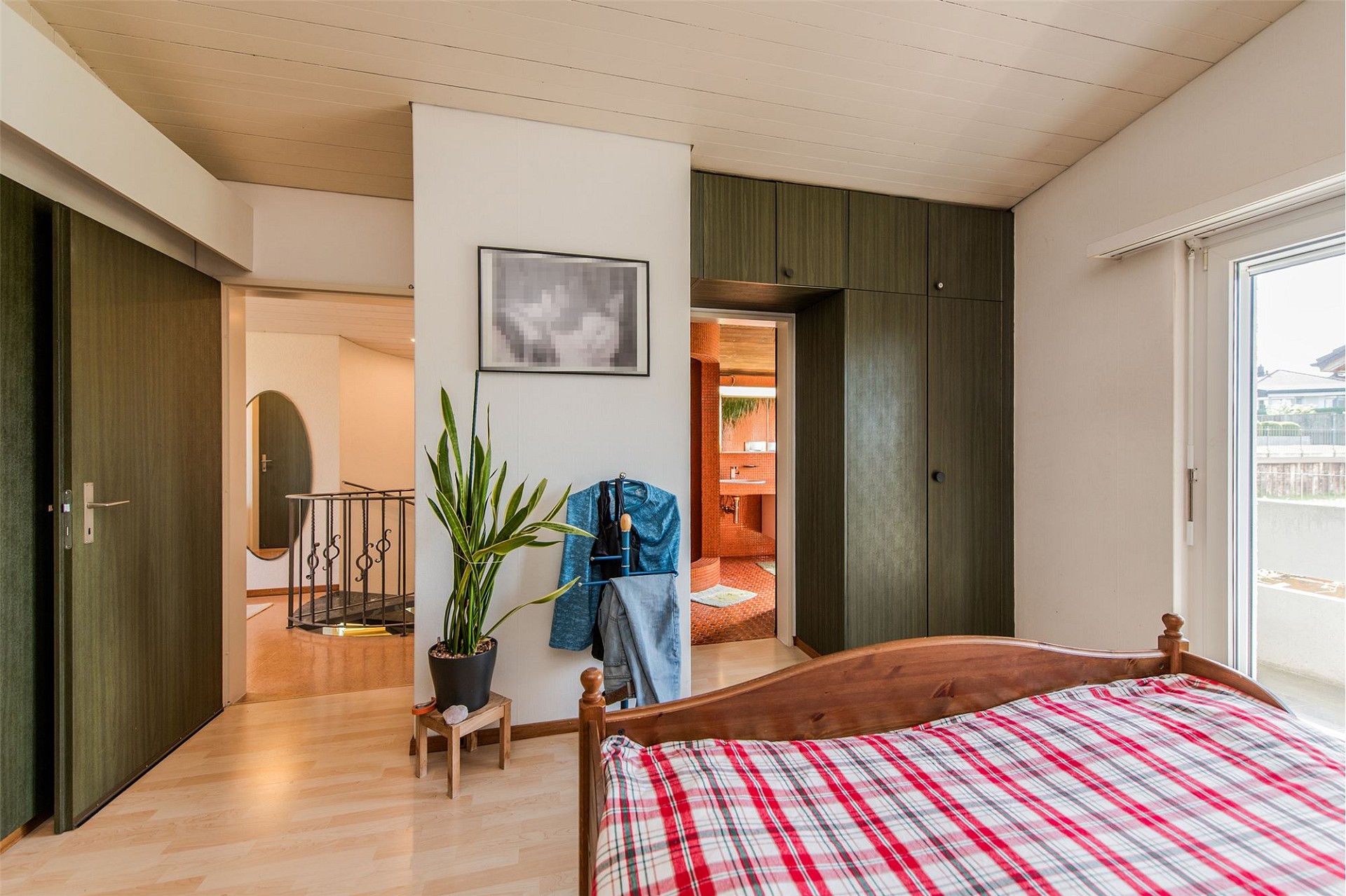 Schlafzimmer mit Einbauschränken und Blick ins Bad