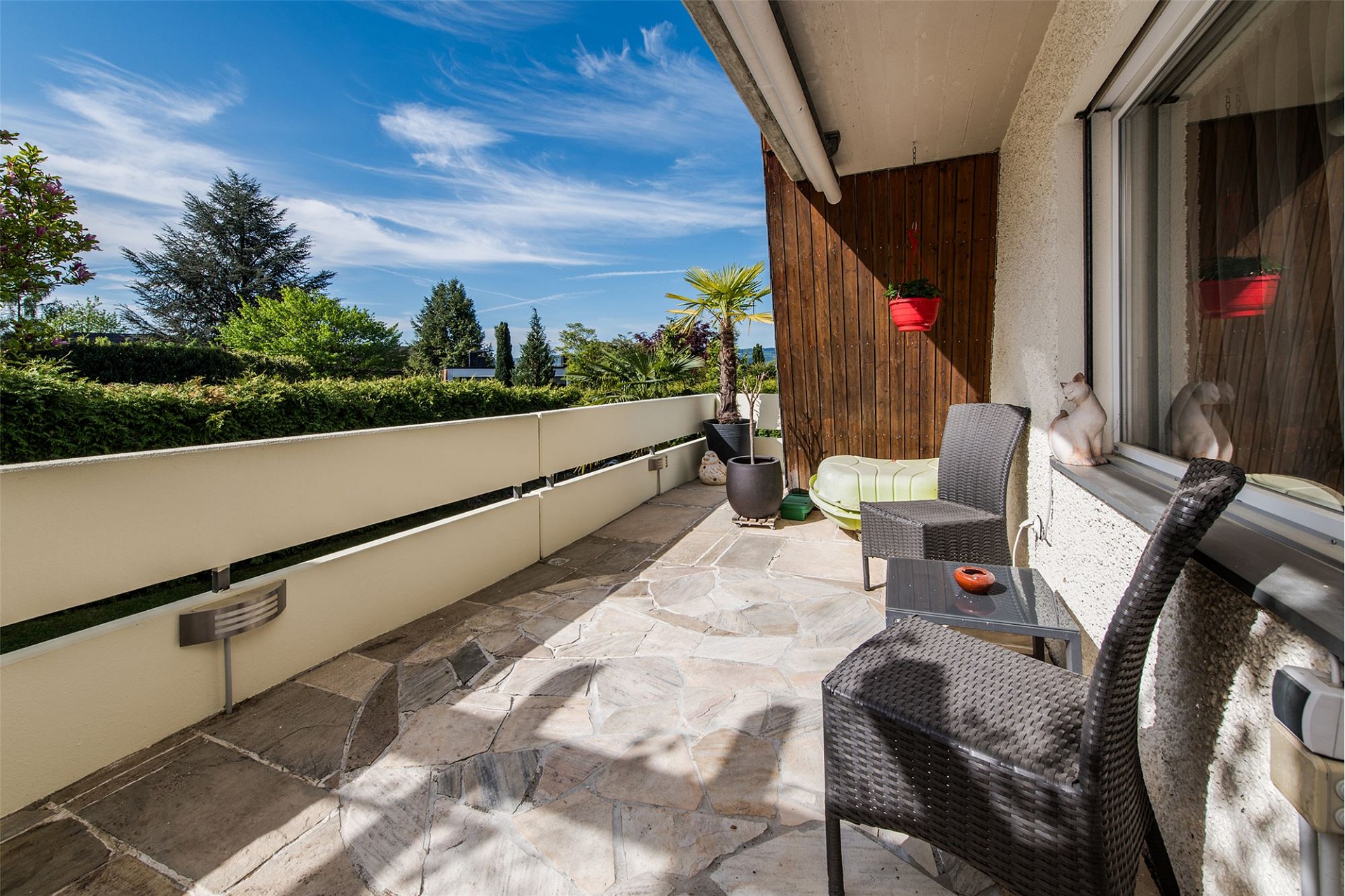 Sonnige Balkon- bzw. Terrassenszene mit Sitzbereich