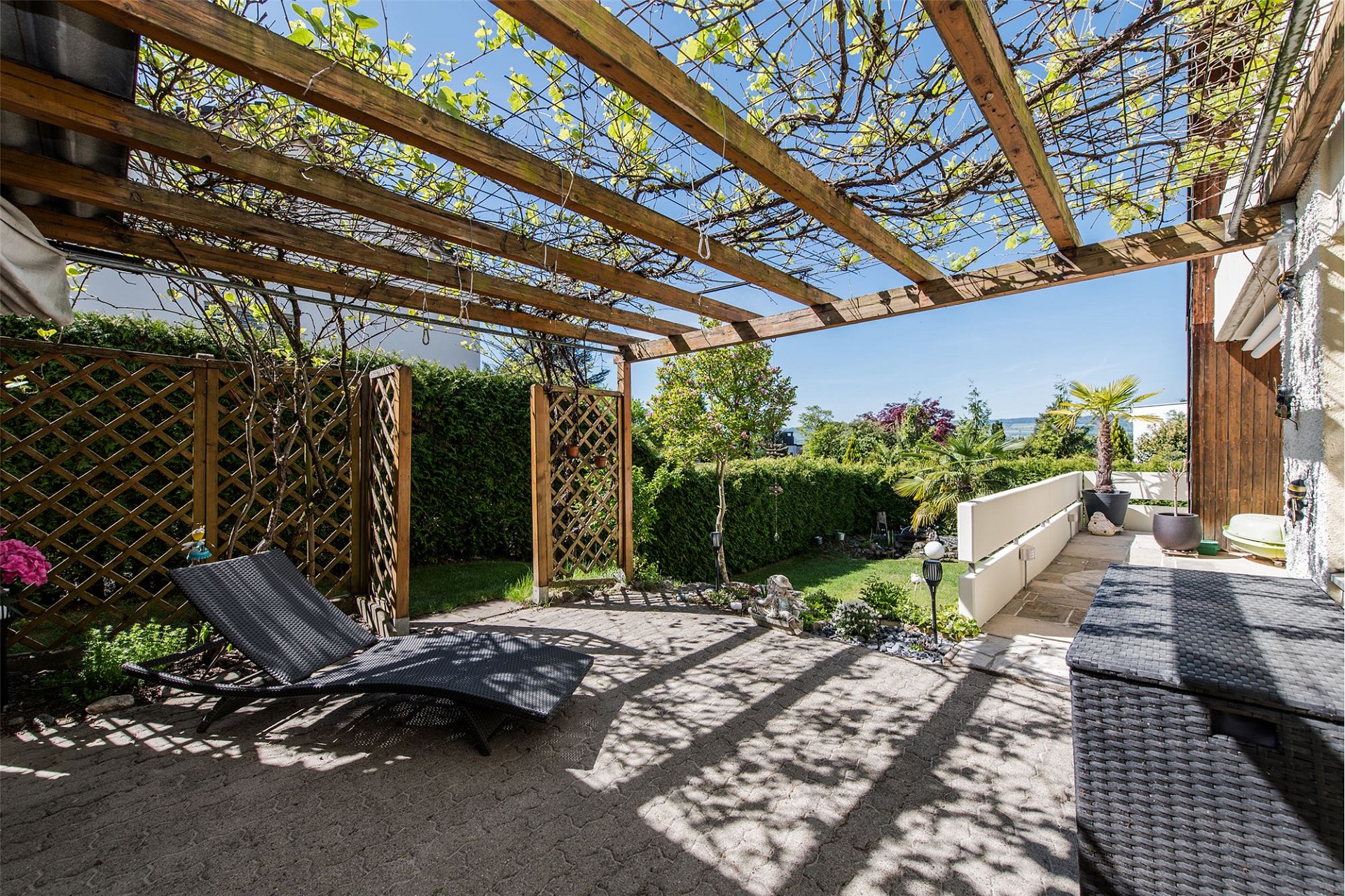 Überdachte Garten-Terrasse mit Pergola und Liege