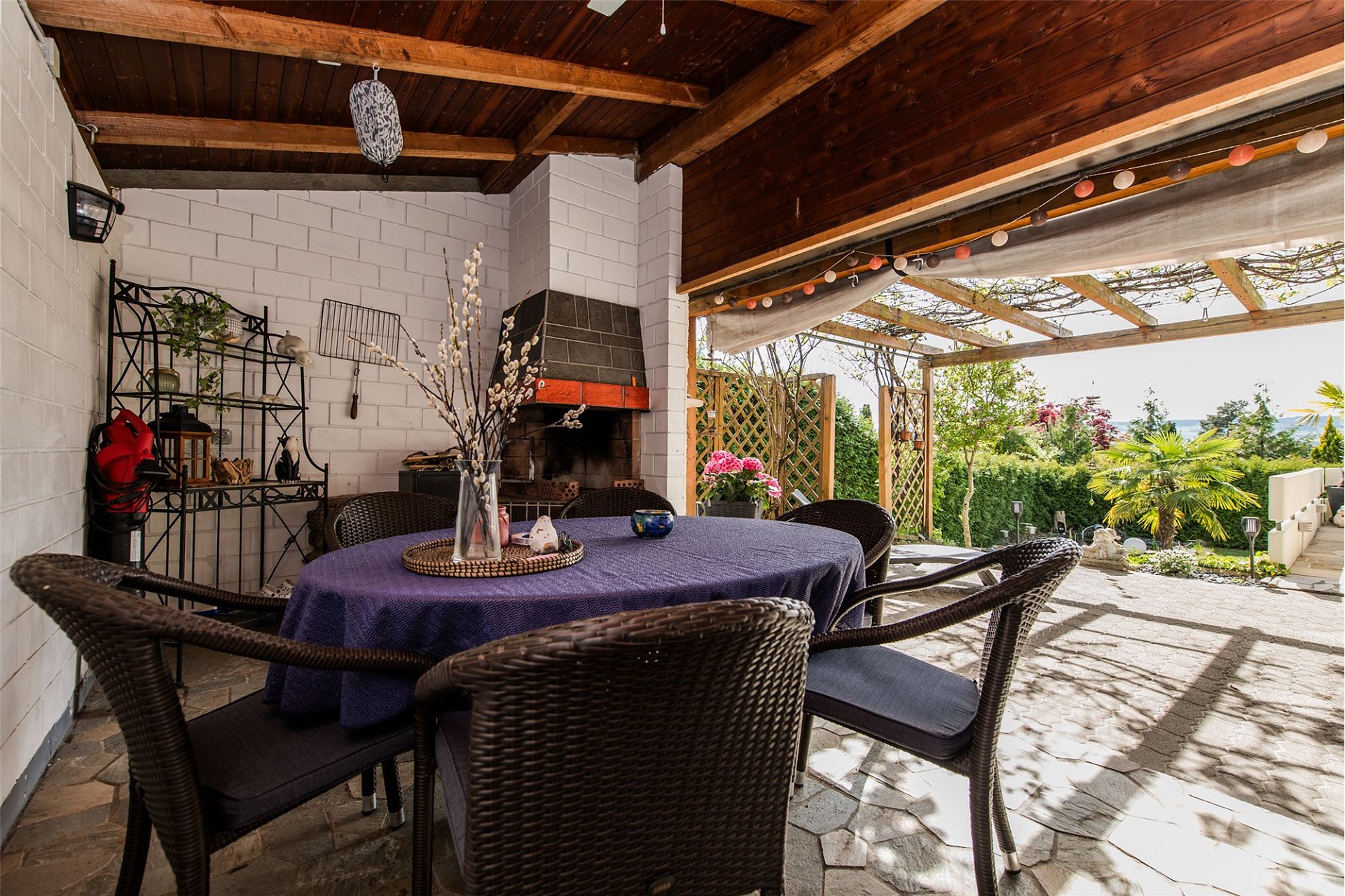 Überdachte Terrasse mit Essbereich und Grill