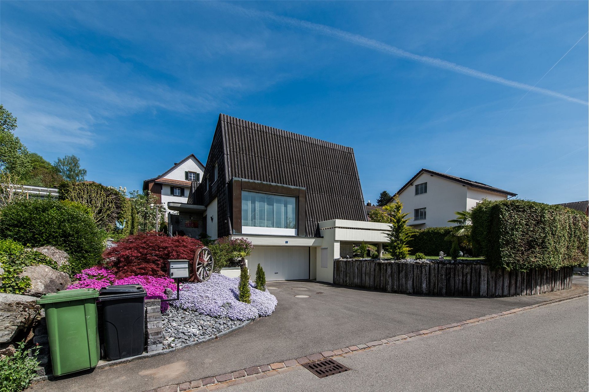 Modernes Einfamilienhaus mit geneigtem Dach und Vorgarten
