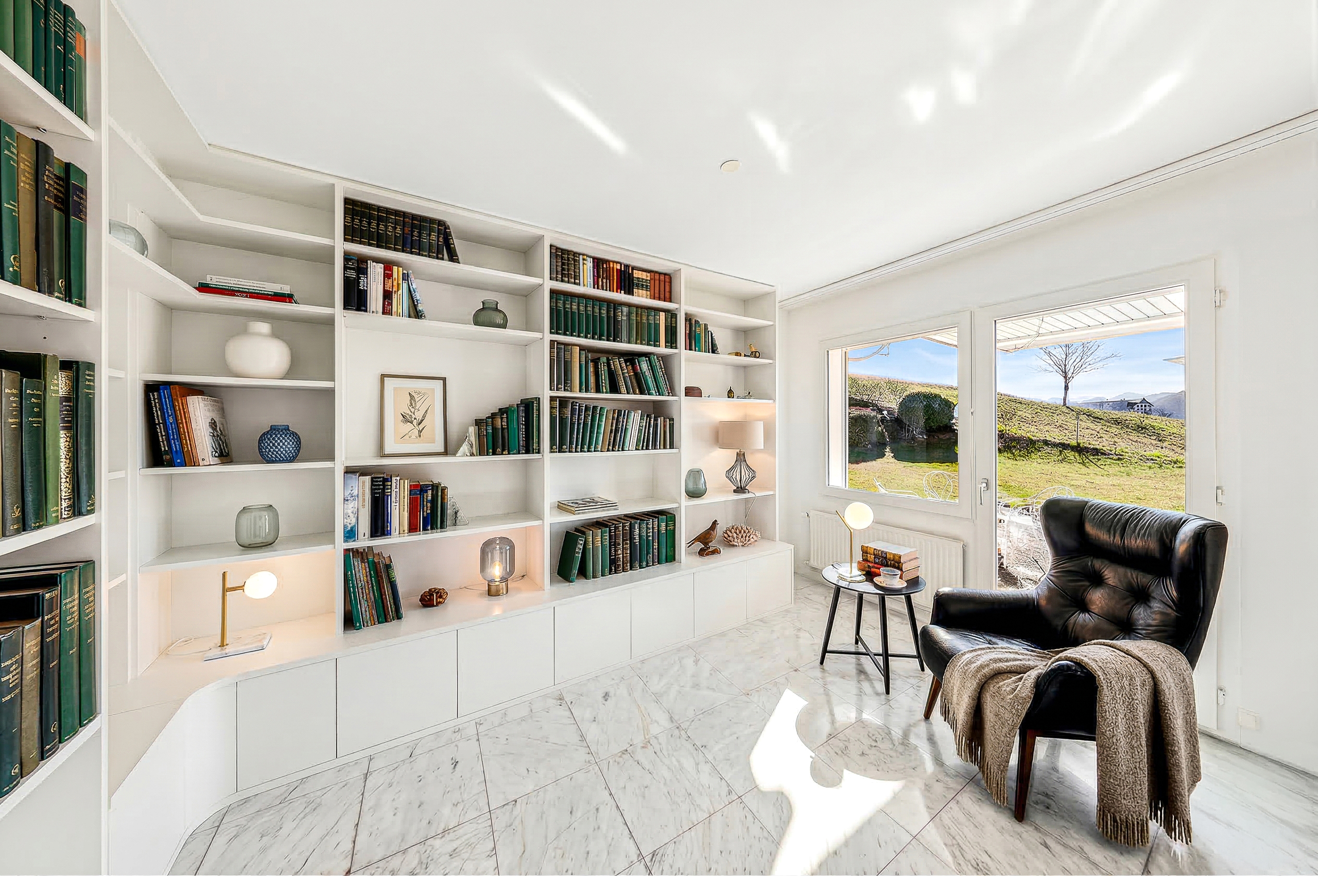 Heller Wohnraum mit Bibliothekswand und Gartenblick