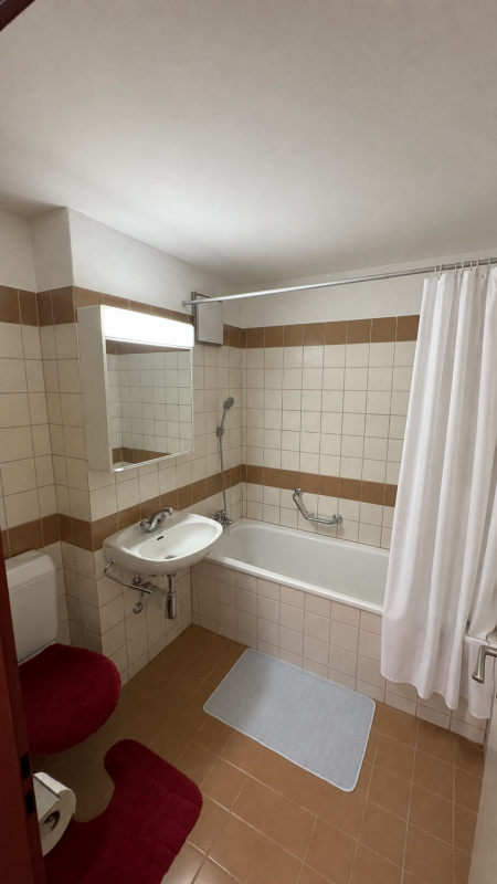 Kleines Badezimmer mit Wanne und Wandwaschbecken