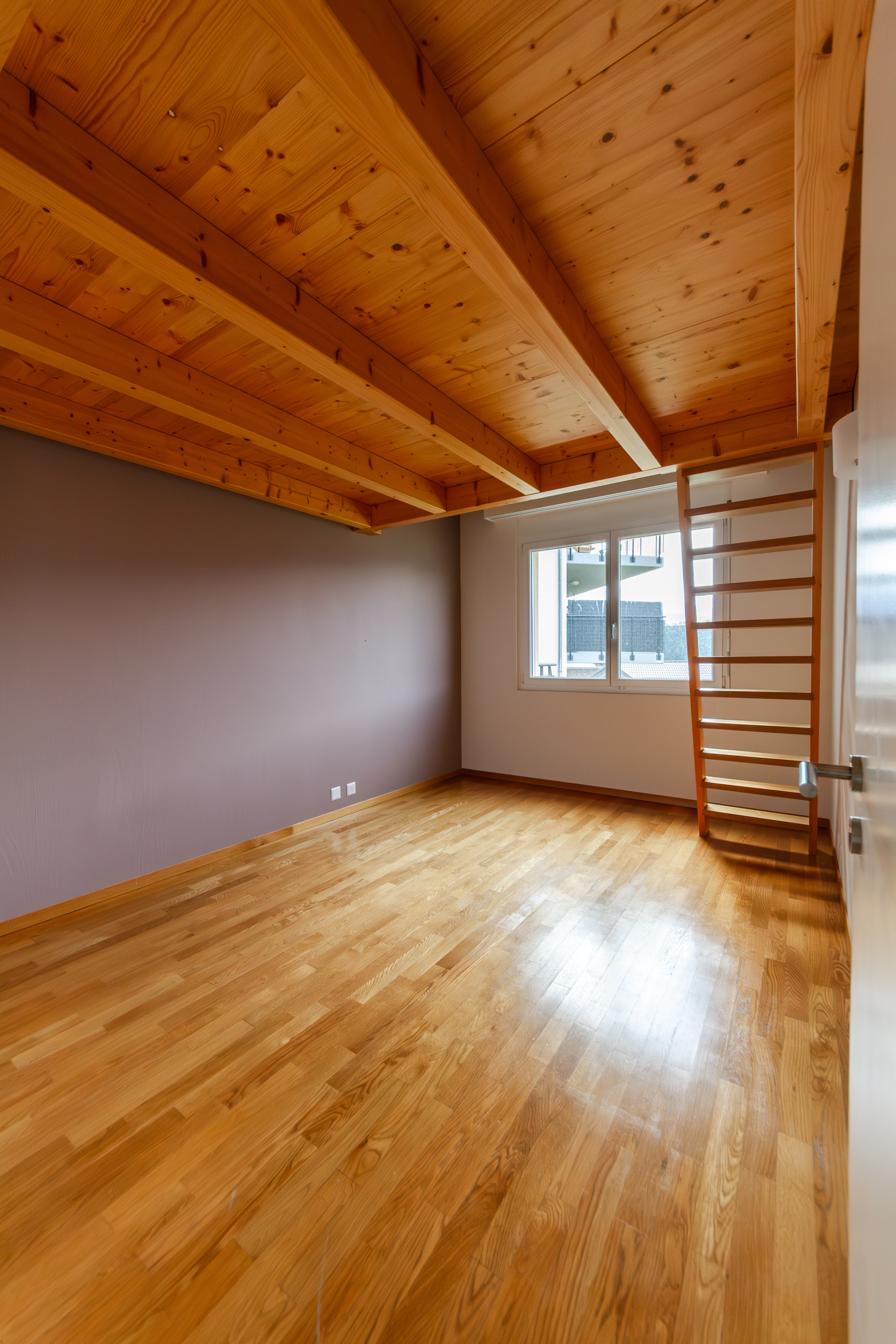 Heller Raum mit Holzbalkendecke und Parkettboden
