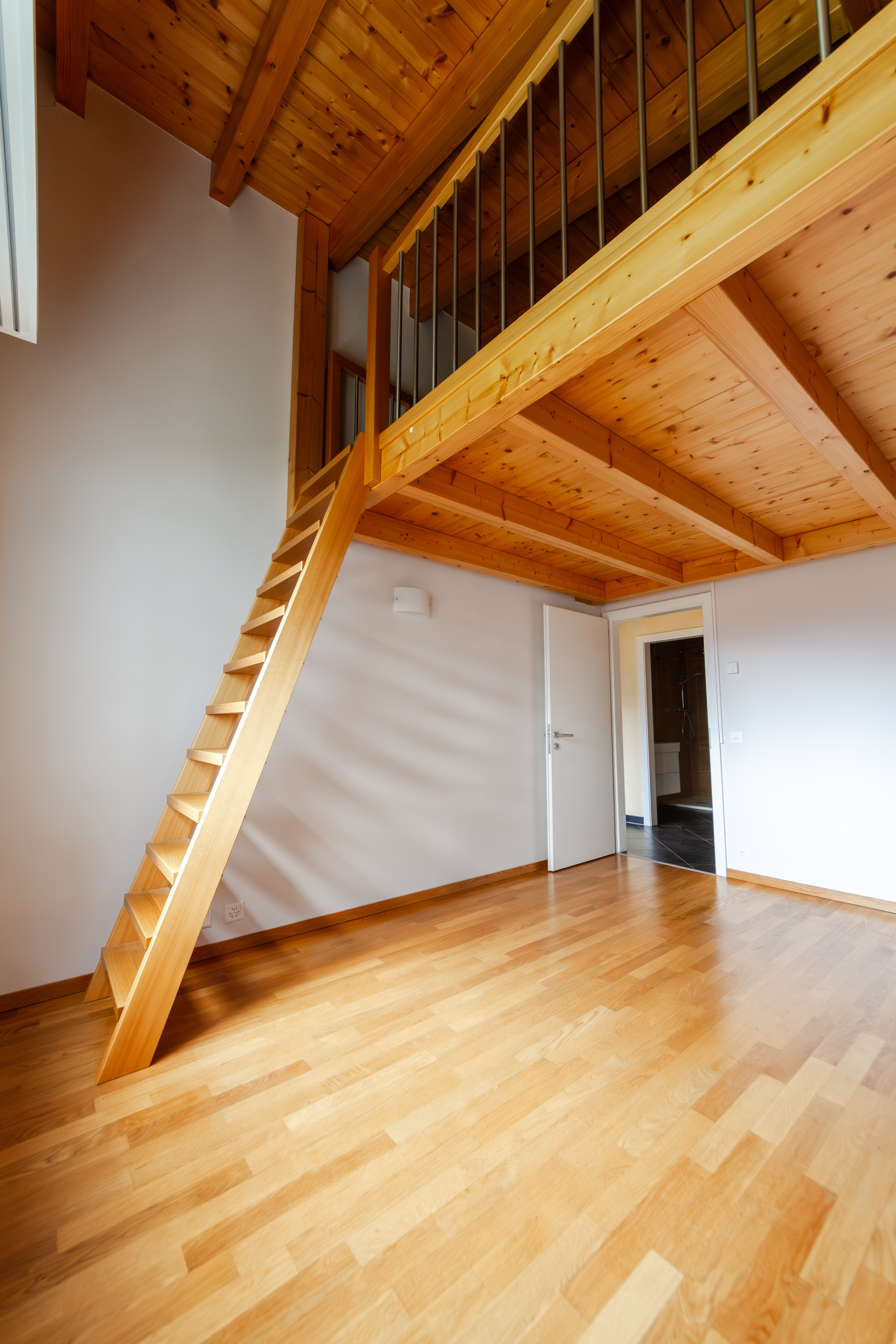 Heller Raum mit Holztreppe und Galerie