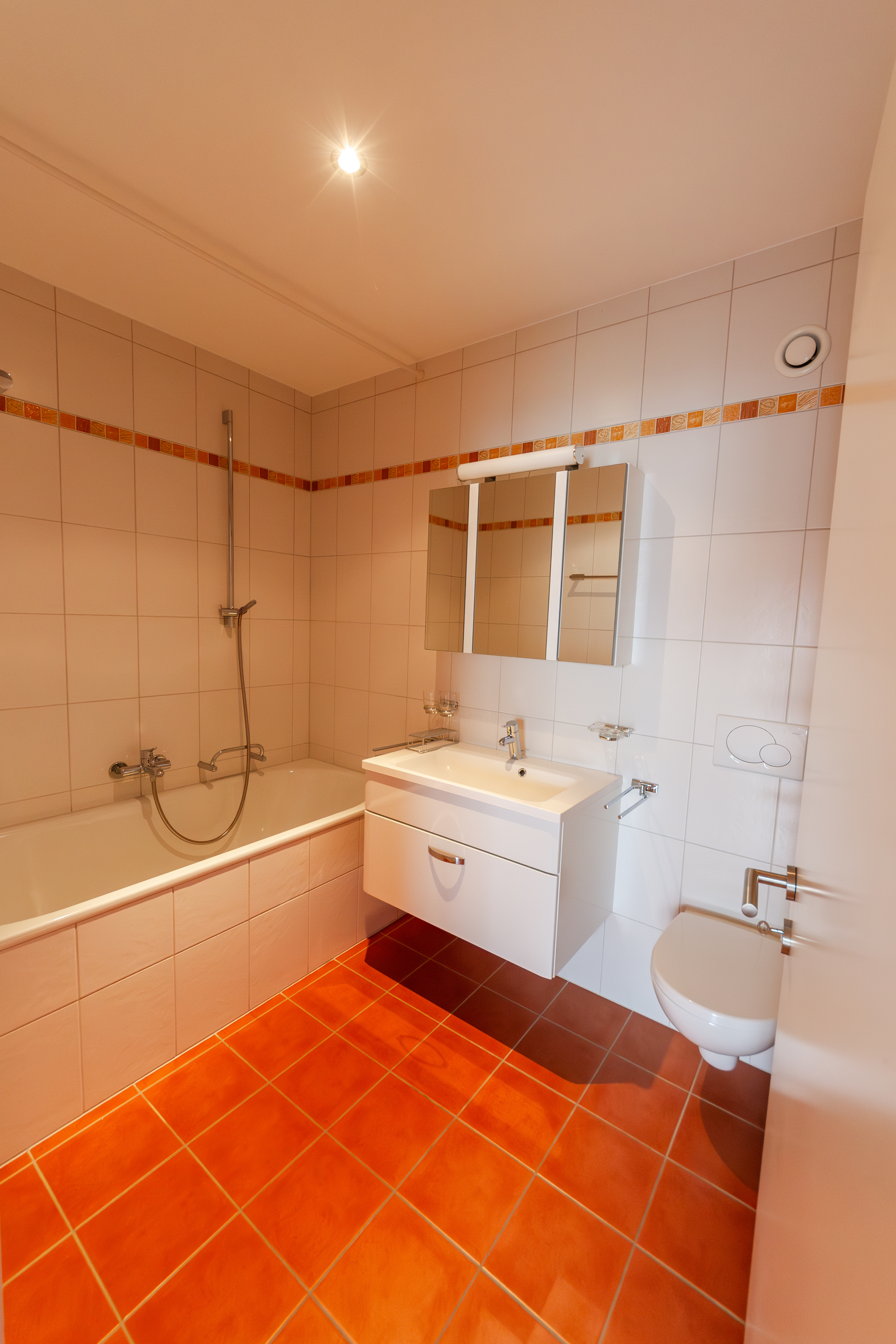Kompaktes Badezimmer mit Wanne, Waschtisch und WC