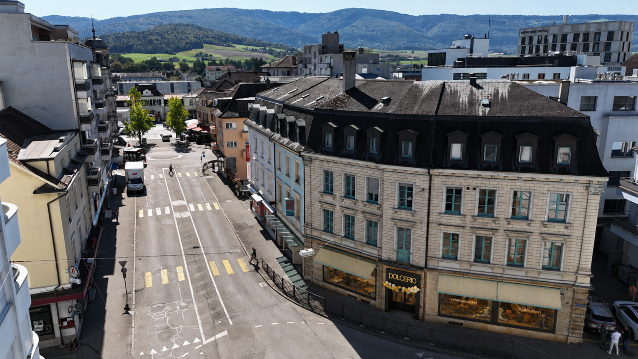 Städtische Straßen- und Dachlandschaft mit Bergkulisse