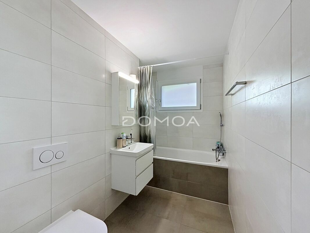 Modernes Badezimmer mit Wanne und weißen Wandfliesen