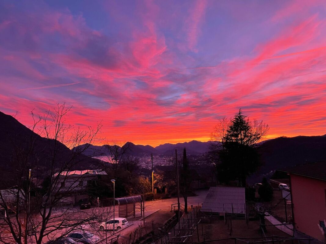 Sonnenuntergang über einer Berglandschaft mit Stadtblick