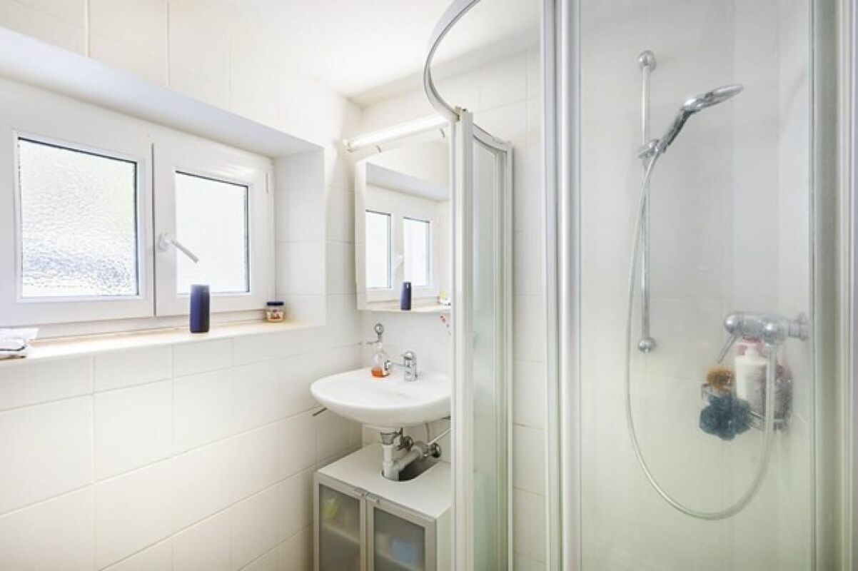 Kleines helles Badezimmer mit Dusche und Fenster