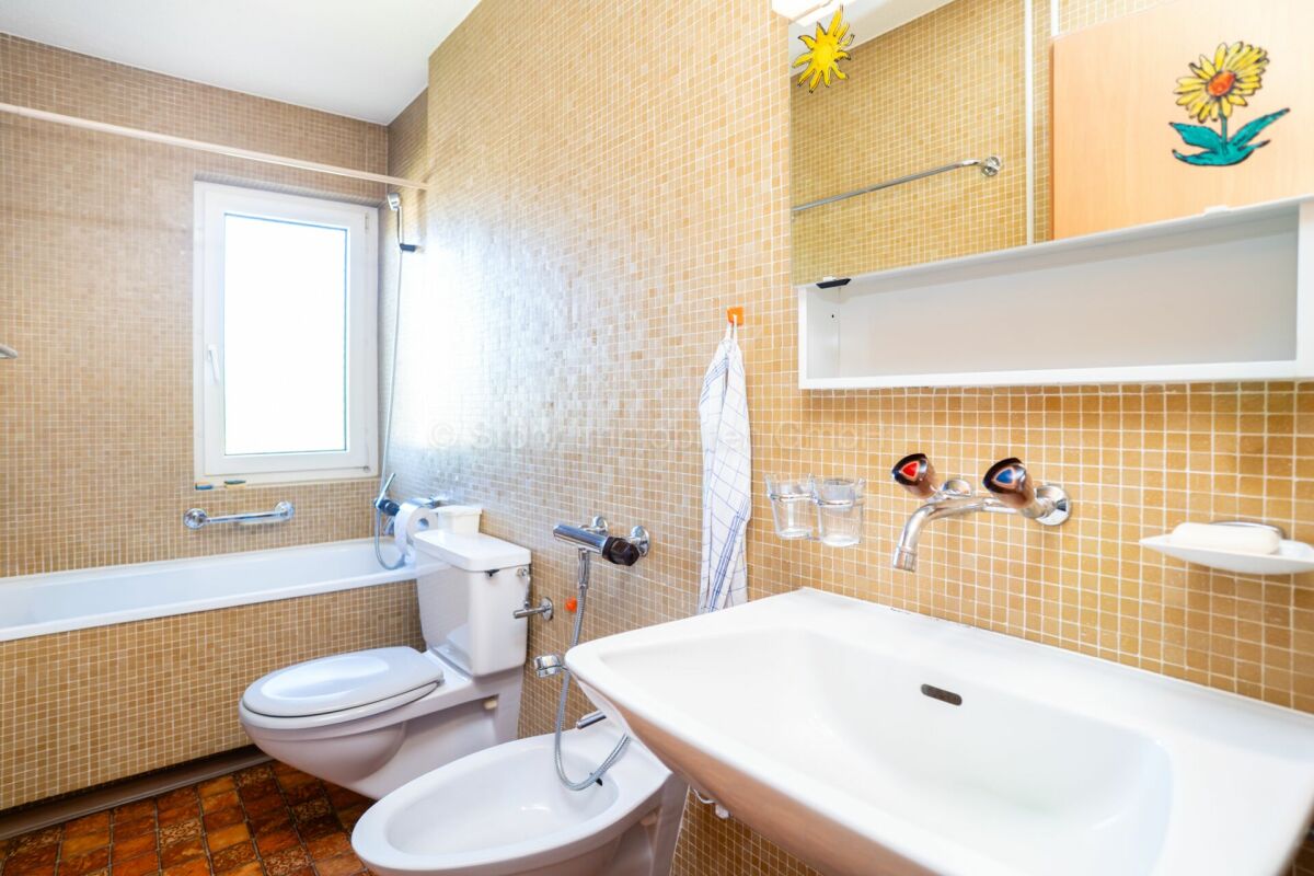 Badezimmer mit gelb-orangefarbenen Mosaikfliesen