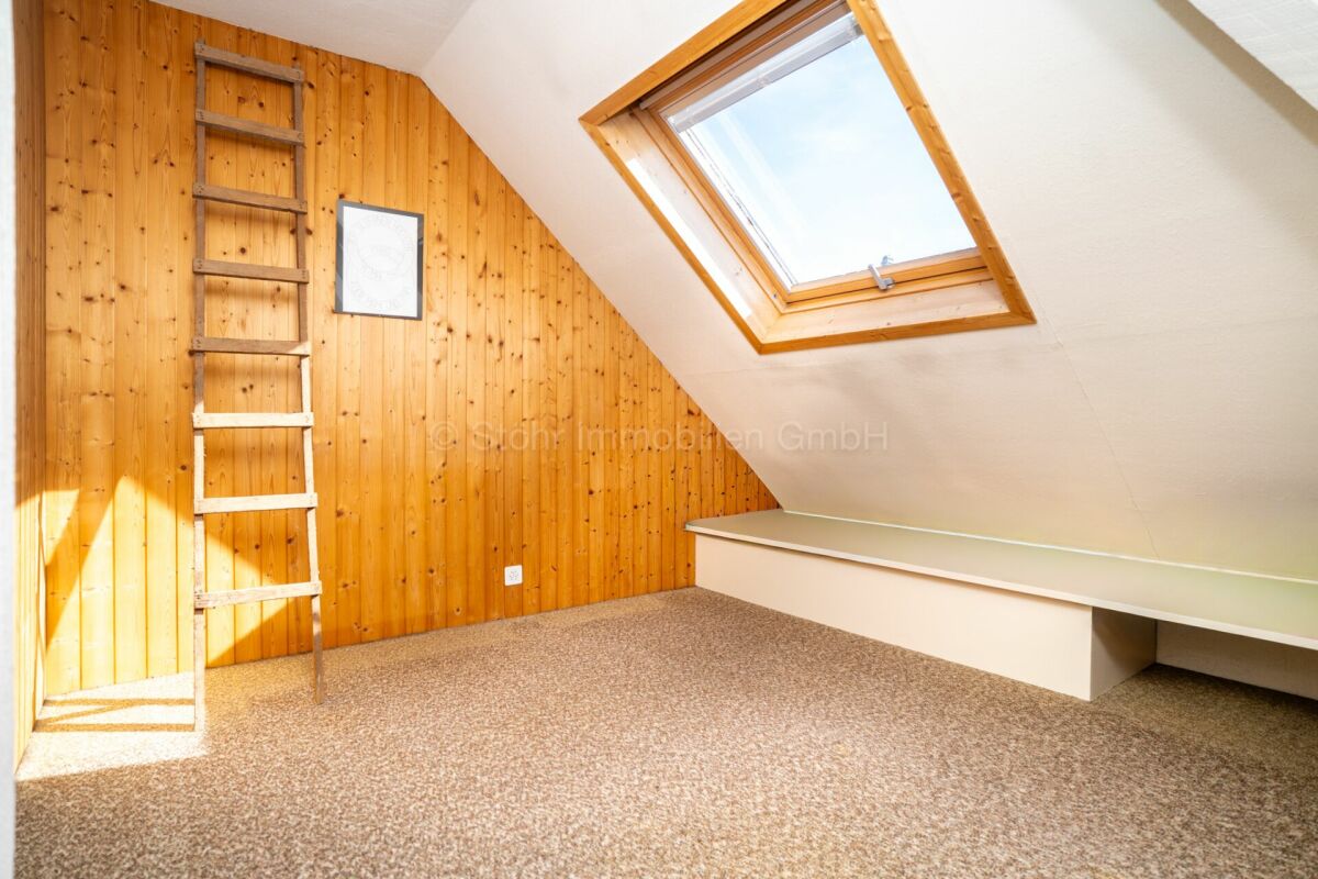 Dachzimmer mit Holzvertäfelung und Dachfenster