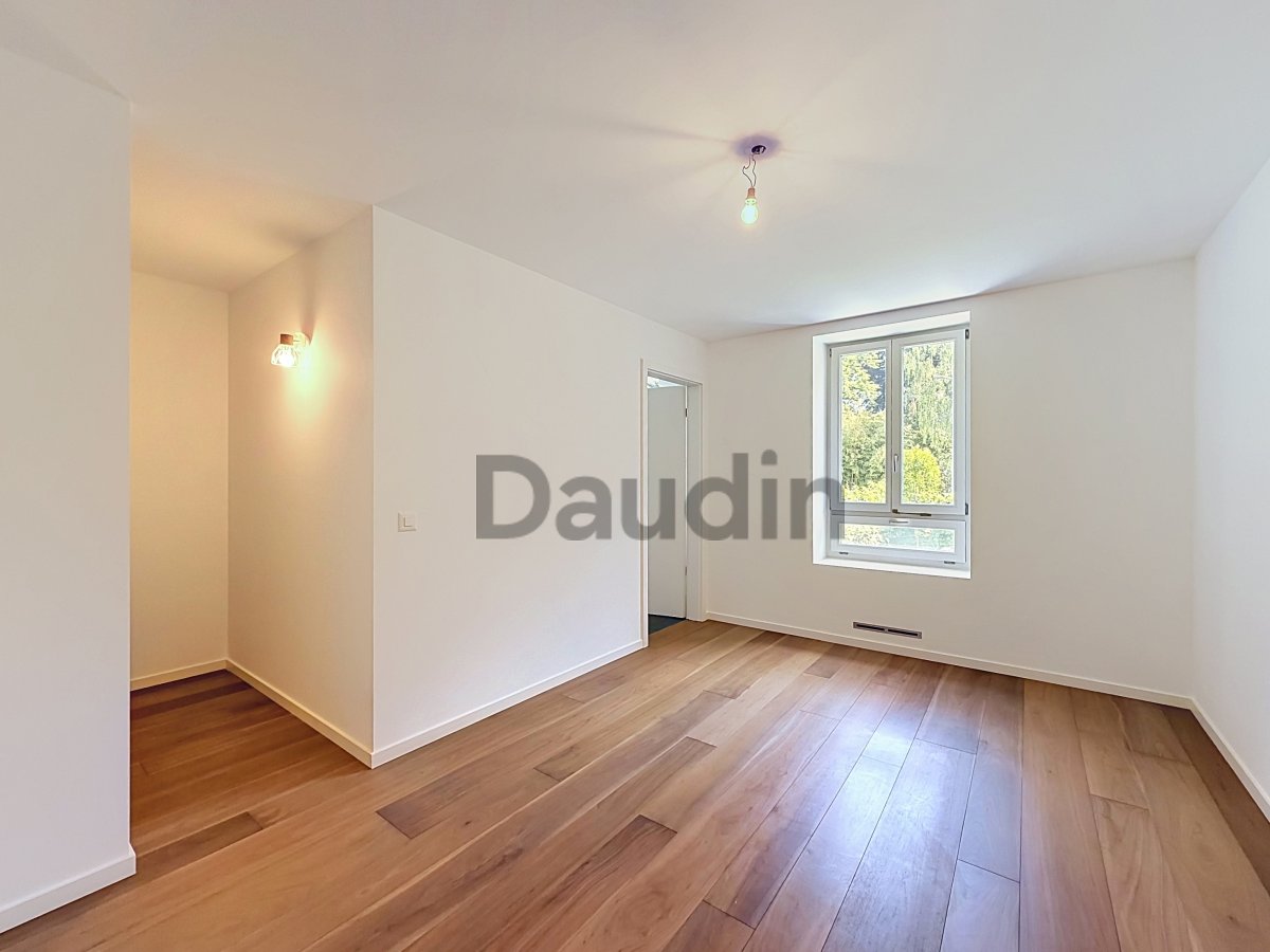 Heller leerer Wohnraum mit Holzparkett und Fenster