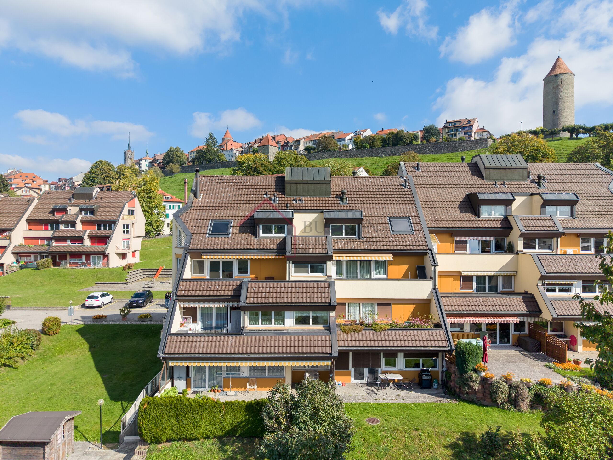 Stadtansicht mit Wohnhäusern und historischem Turm