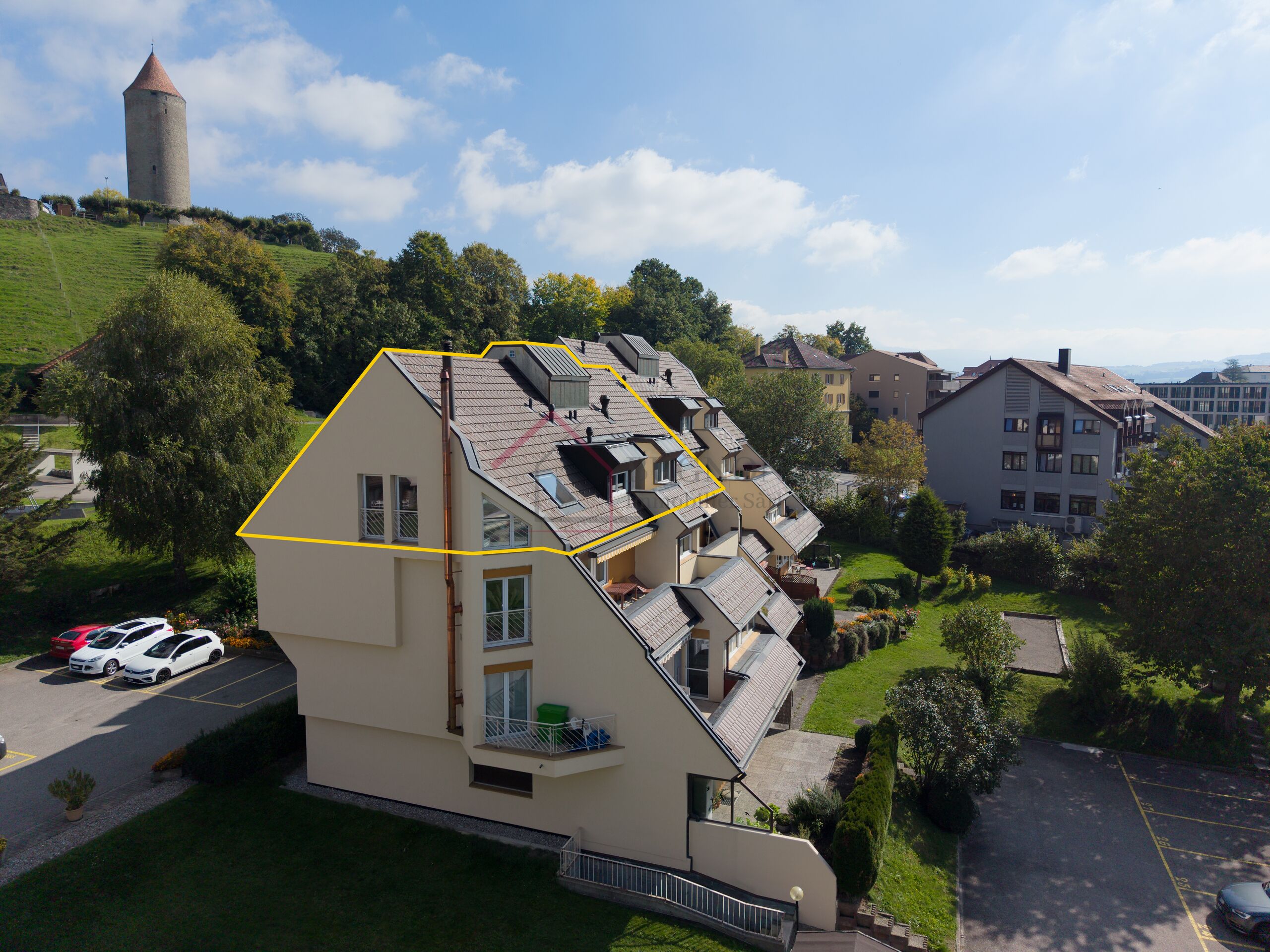 Wohngebäude mit markiertem Dachbereich in grüner Umgebung