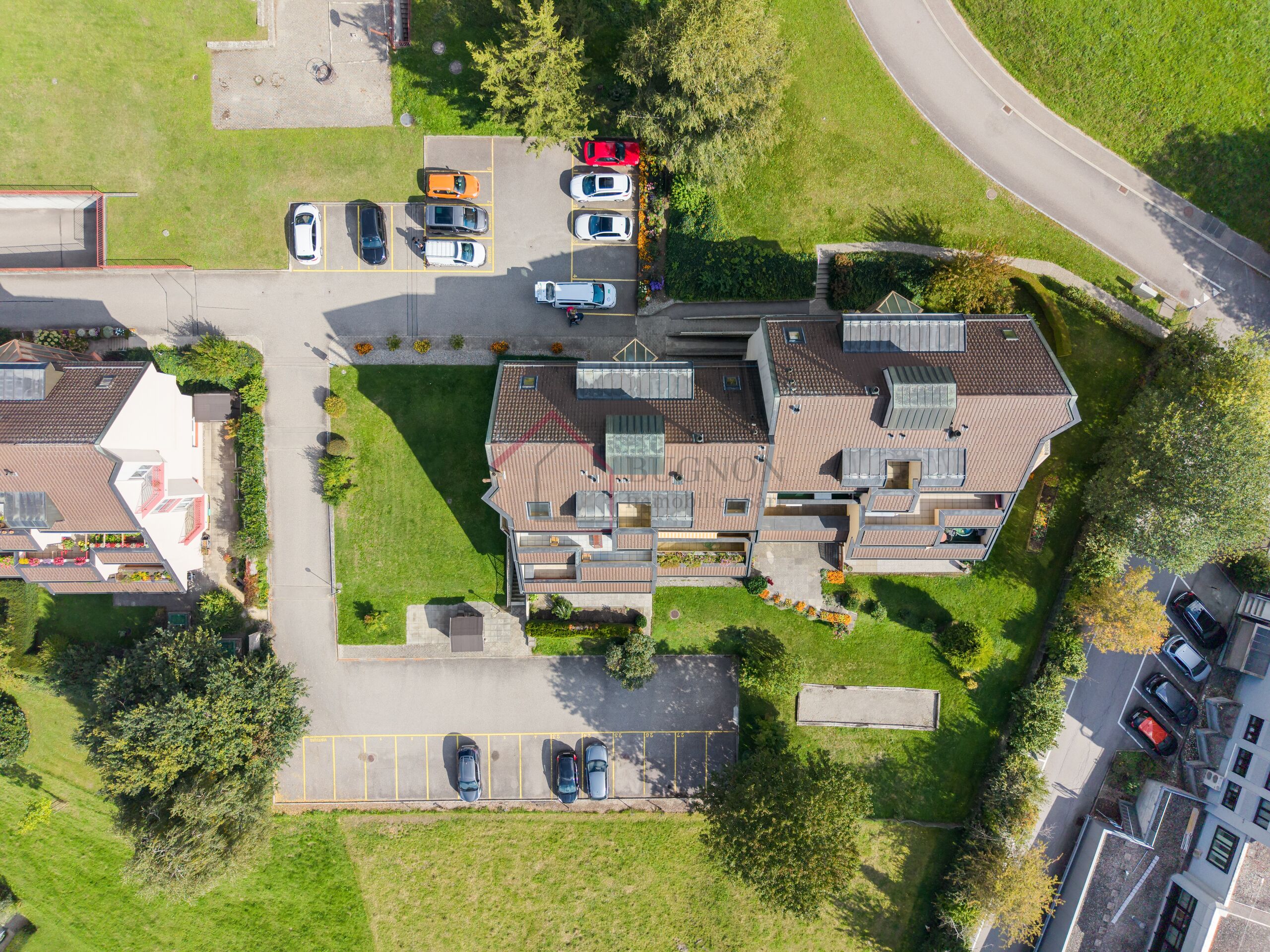Luftaufnahme eines Wohnkomplexes mit Parkplätzen und Grünflächen