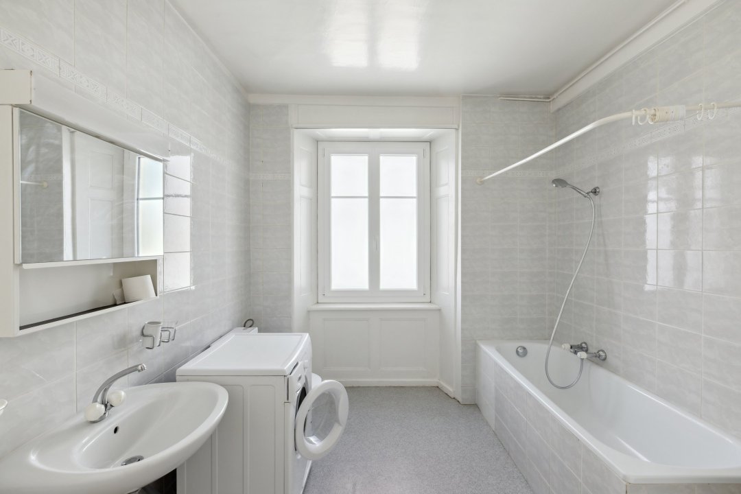 Helles Badezimmer mit Badewanne und Fenster