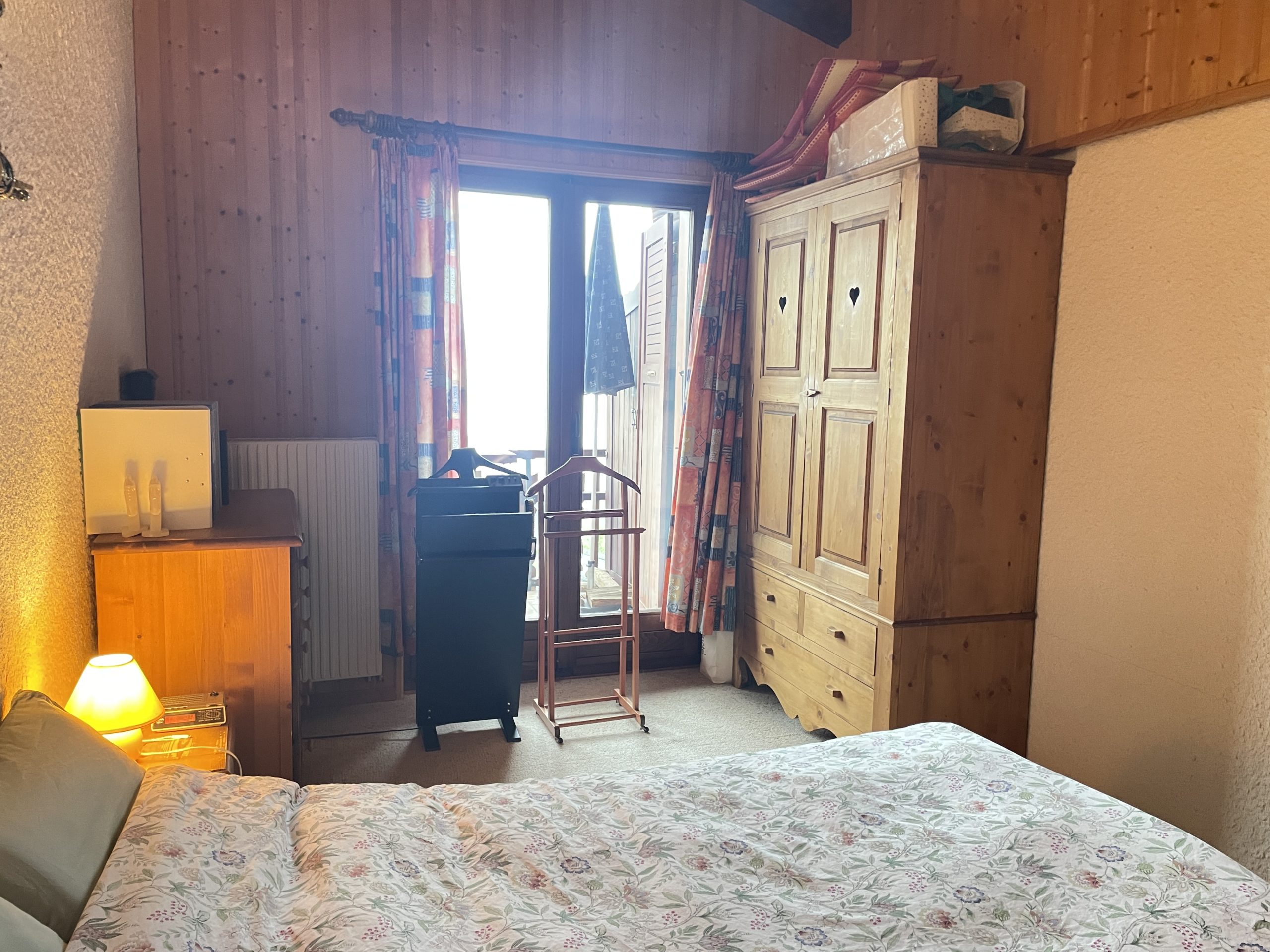 Gemütliches Schlafzimmer mit Holzmöbeln und Balkonzugang