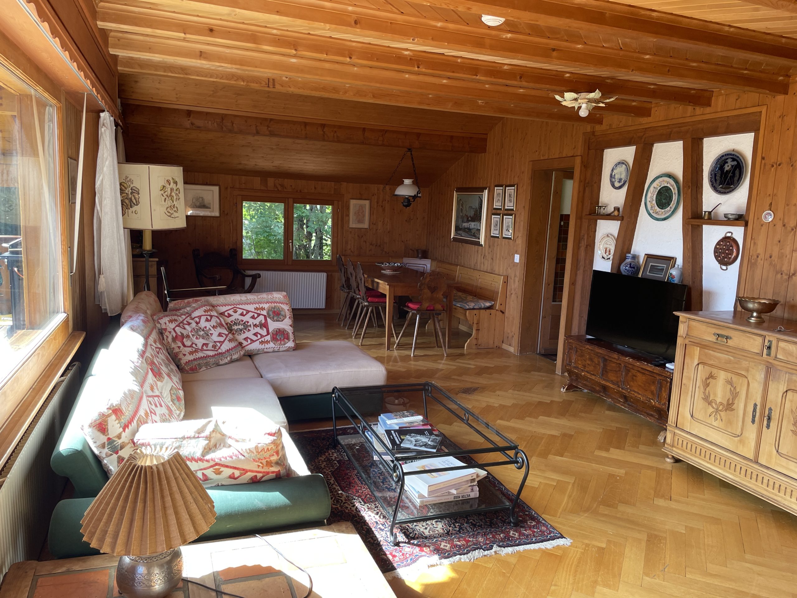 Gemütliches, holzverkleidetes Wohnzimmer mit Essbereich