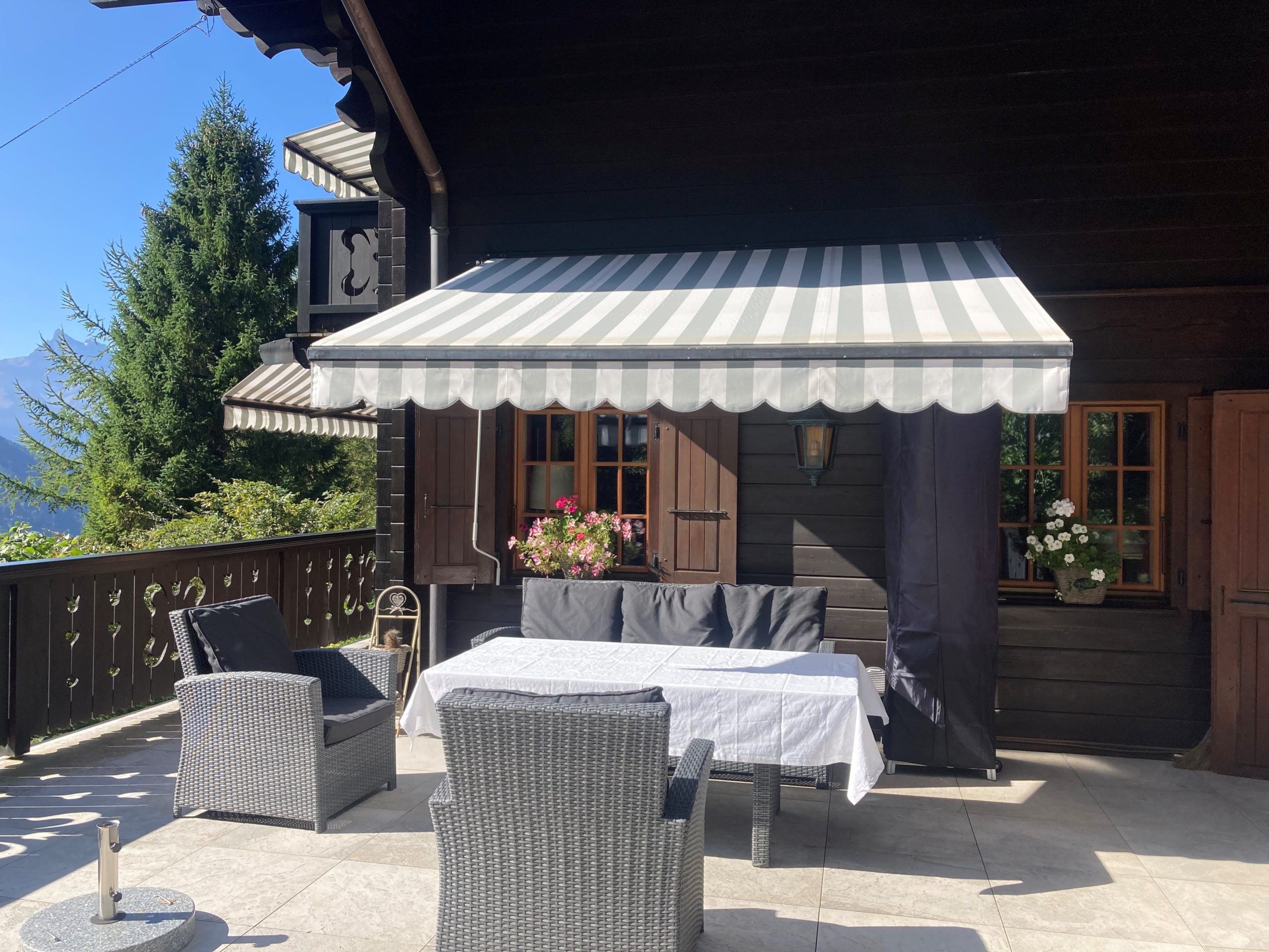 Alpine Terrasse mit Markise und Sitzgruppe