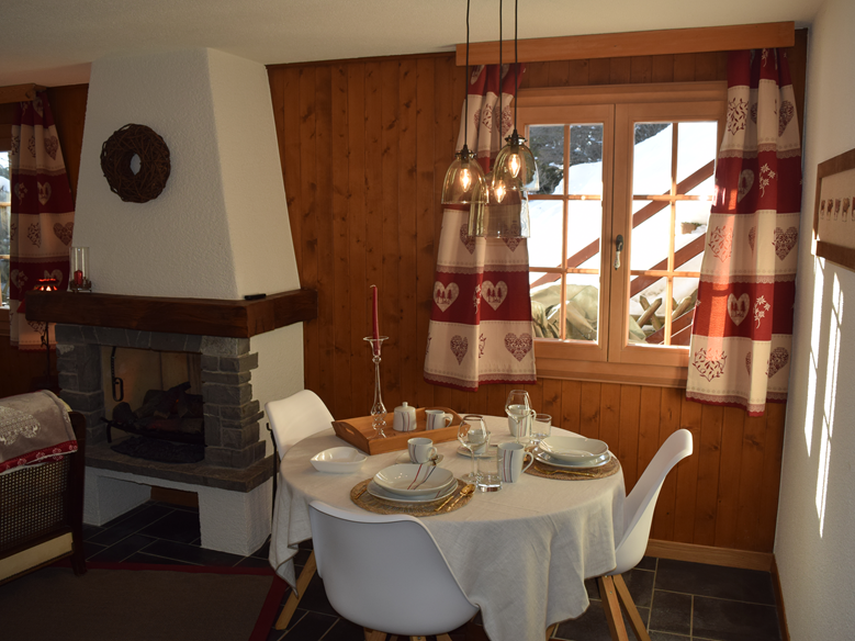 Gemütlicher Essbereich mit Kamin und Holzwand