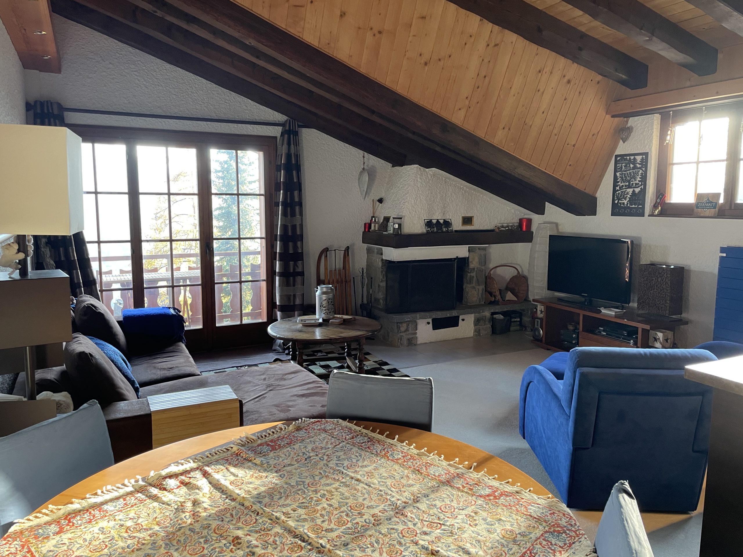 Gemütliches Wohnzimmer mit Kamin und Balkonzugang