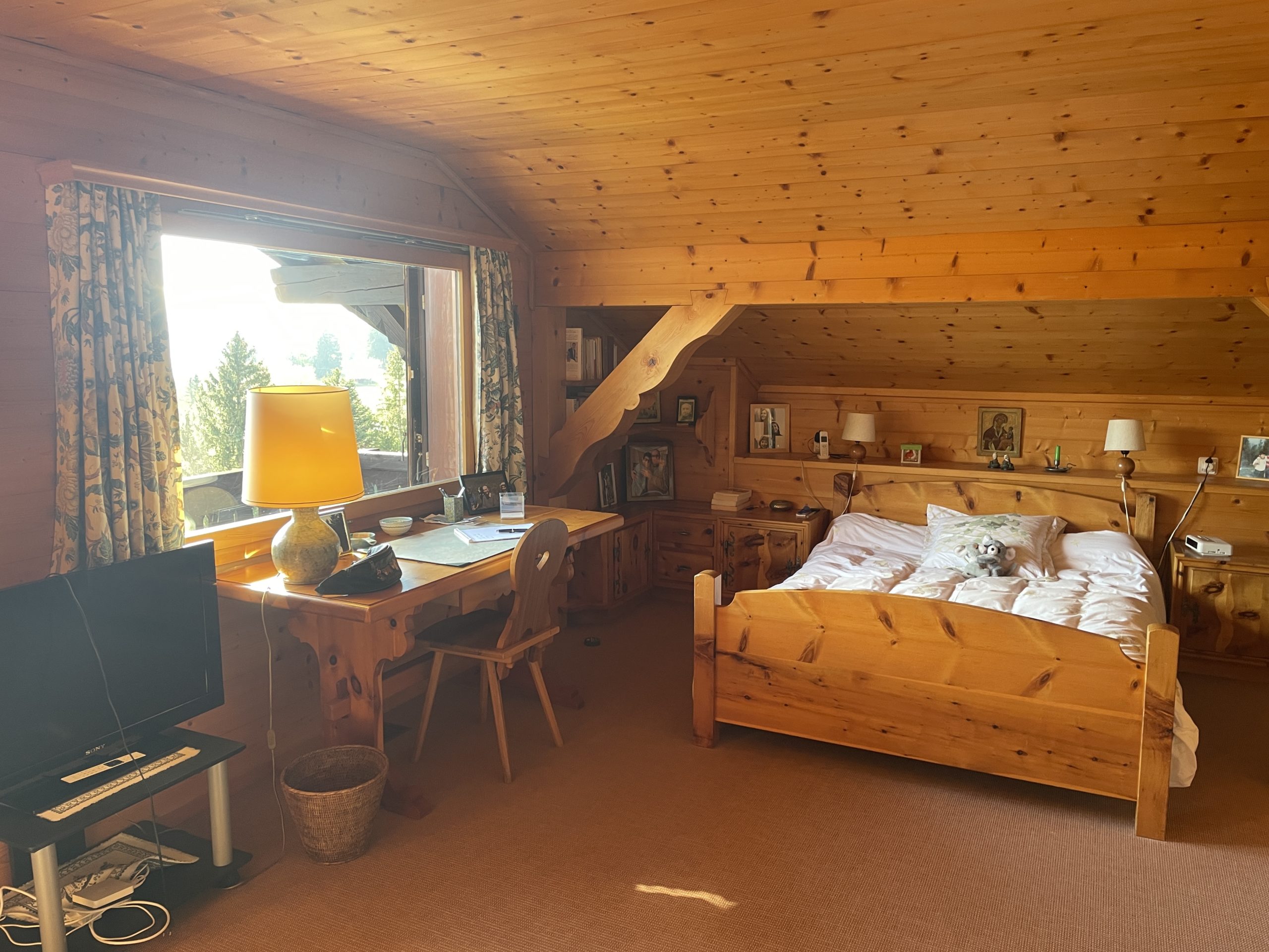 Rustikales Dachgeschoss-Schlafzimmer mit Holzverkleidung