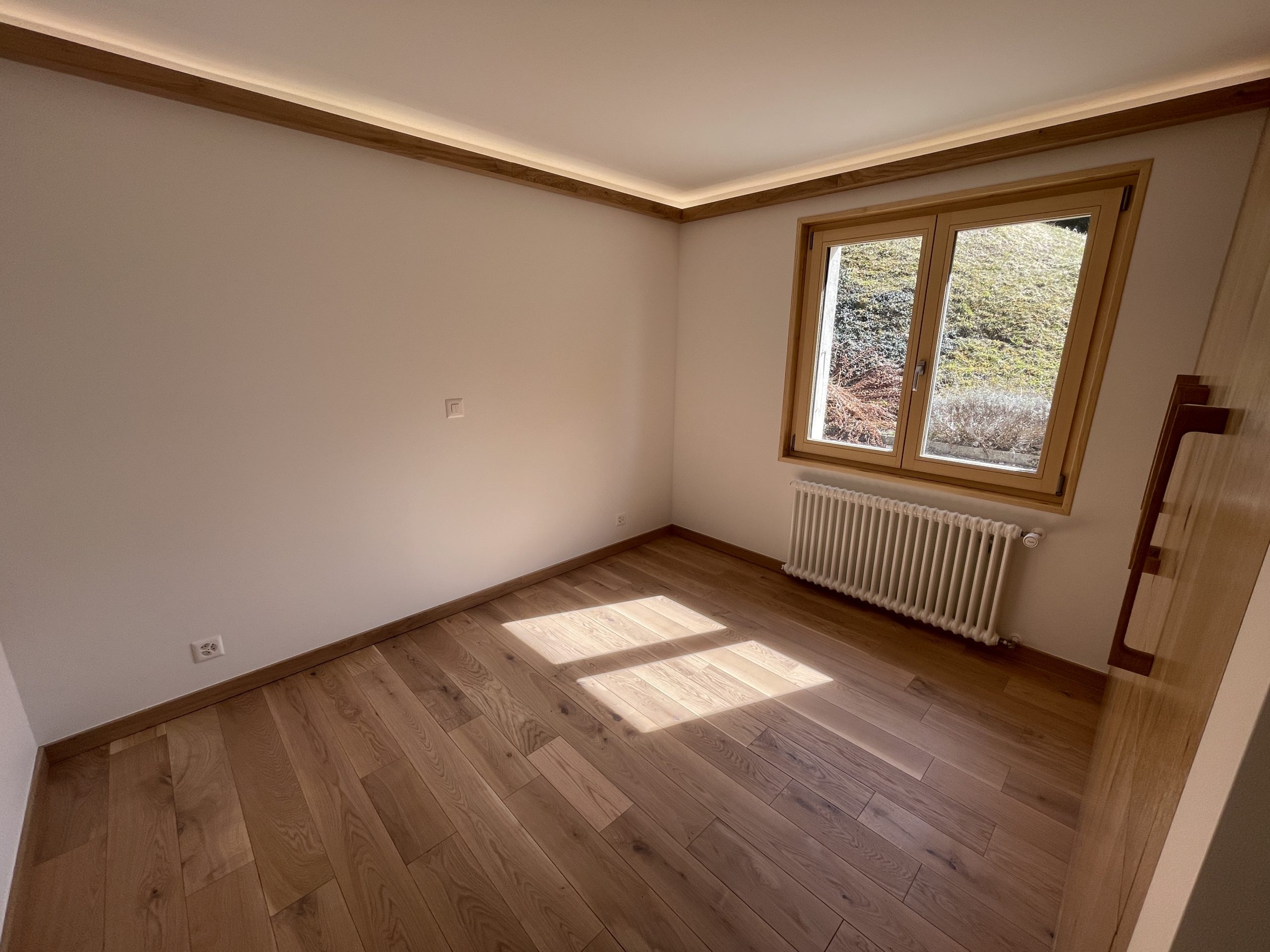 Leerer, heller Raum mit Holzfußboden