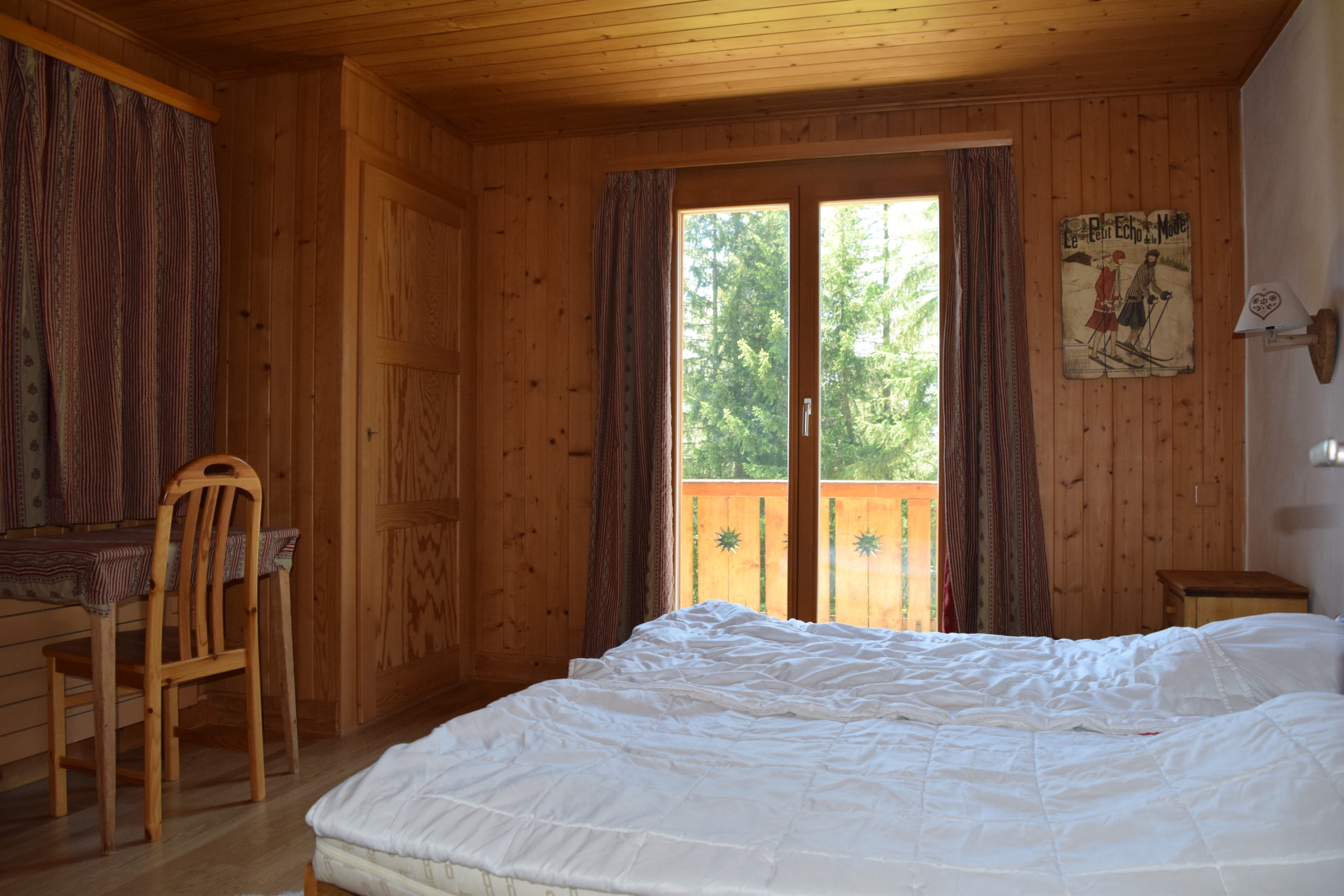 Gemütliches Holzschlafzimmer mit Balkonblick