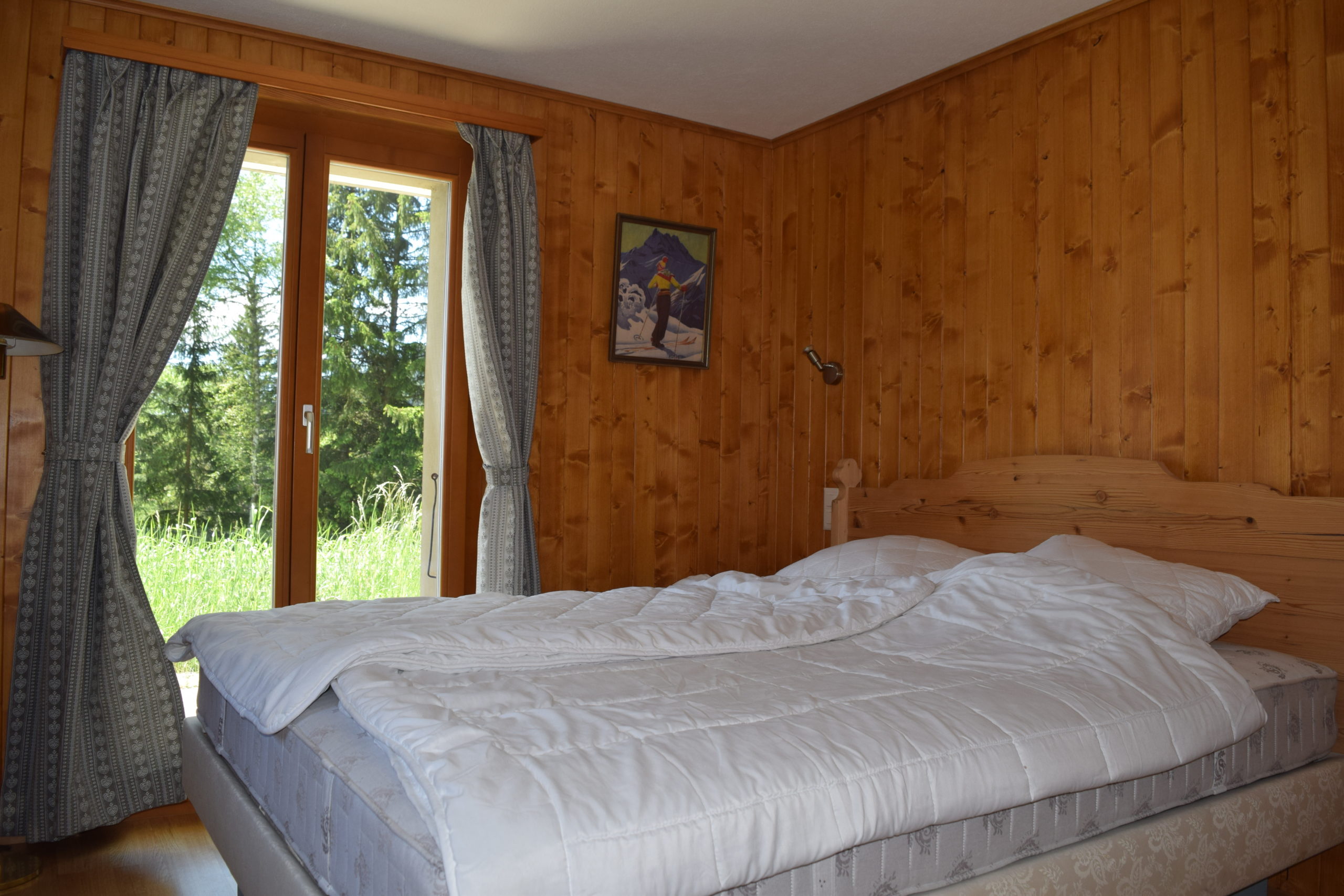 Gemütliches Schlafzimmer mit Holzwandverkleidung