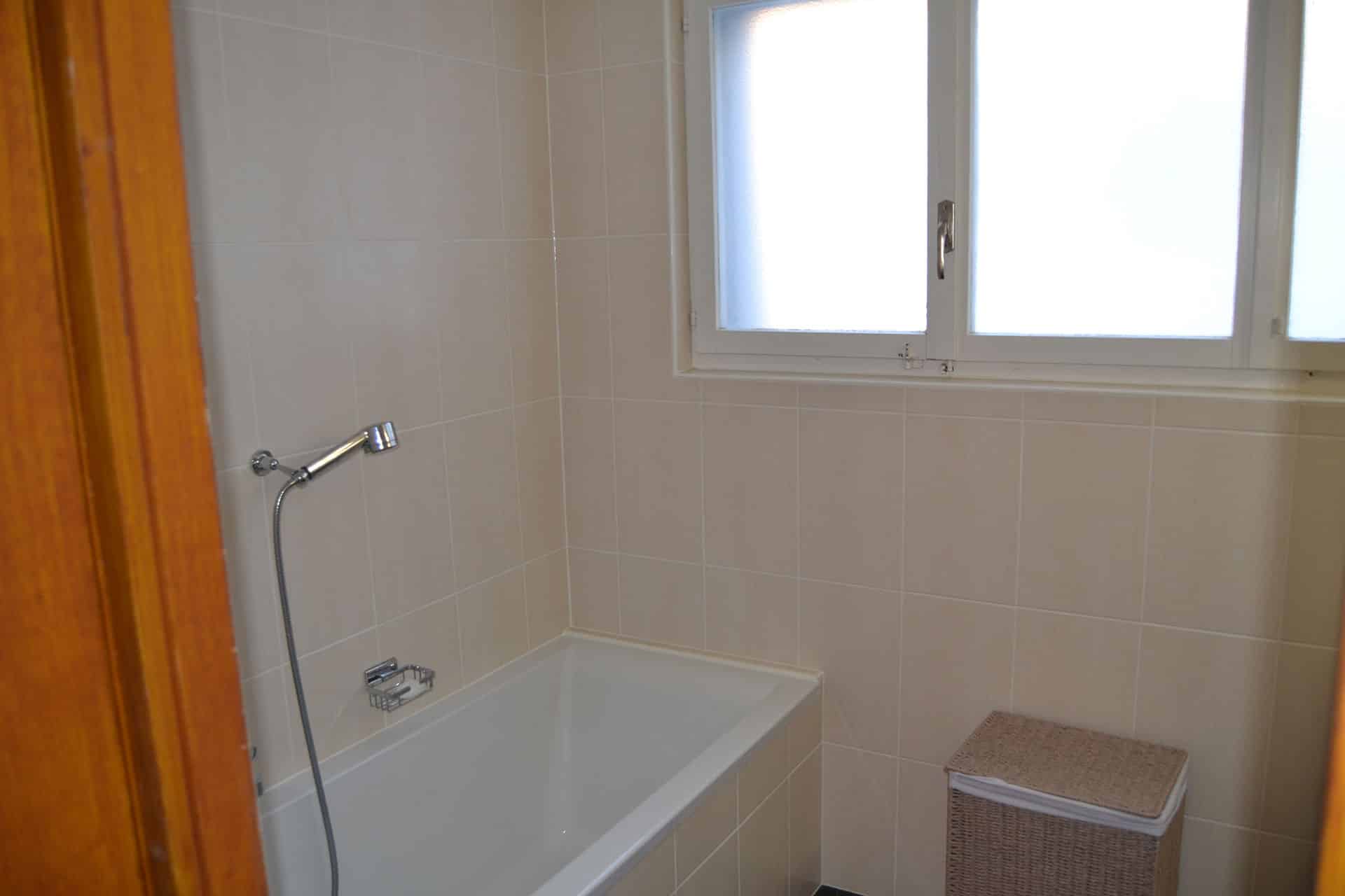 Badezimmer mit Badewanne und Fenster