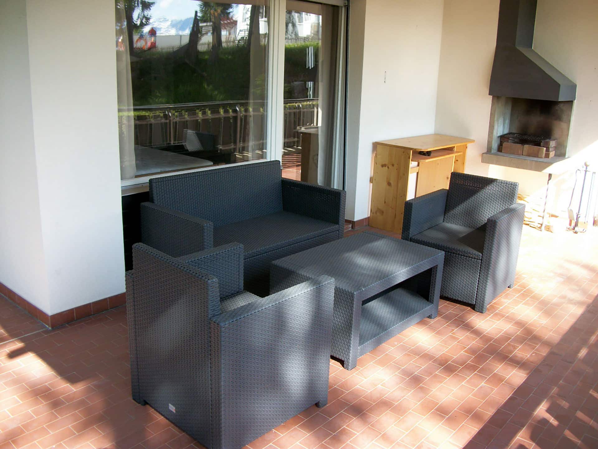 Überdachte Terrasse mit Sitzgruppe und Grill