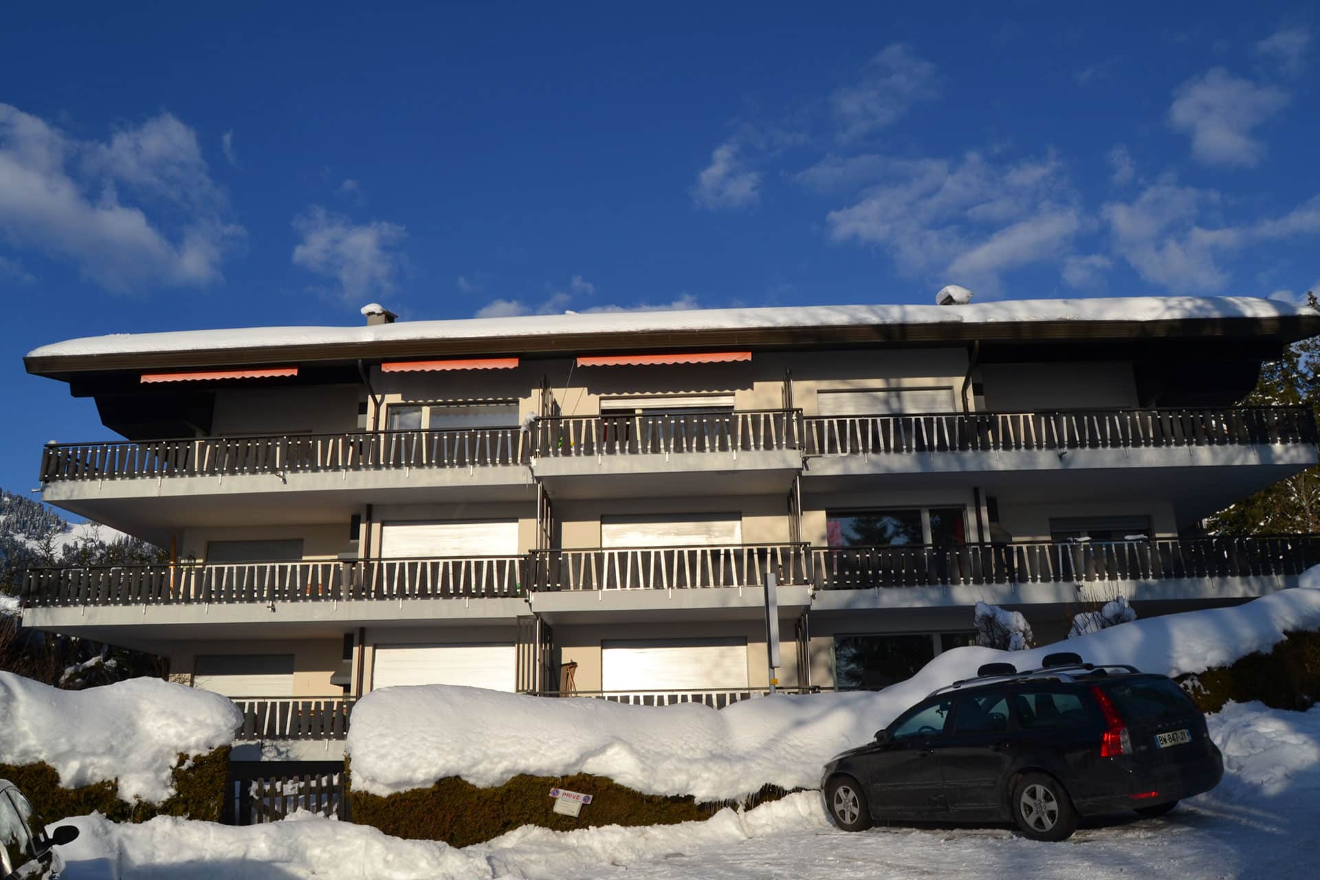 Schneebedecktes Mehrfamilienhaus mit Balkonen