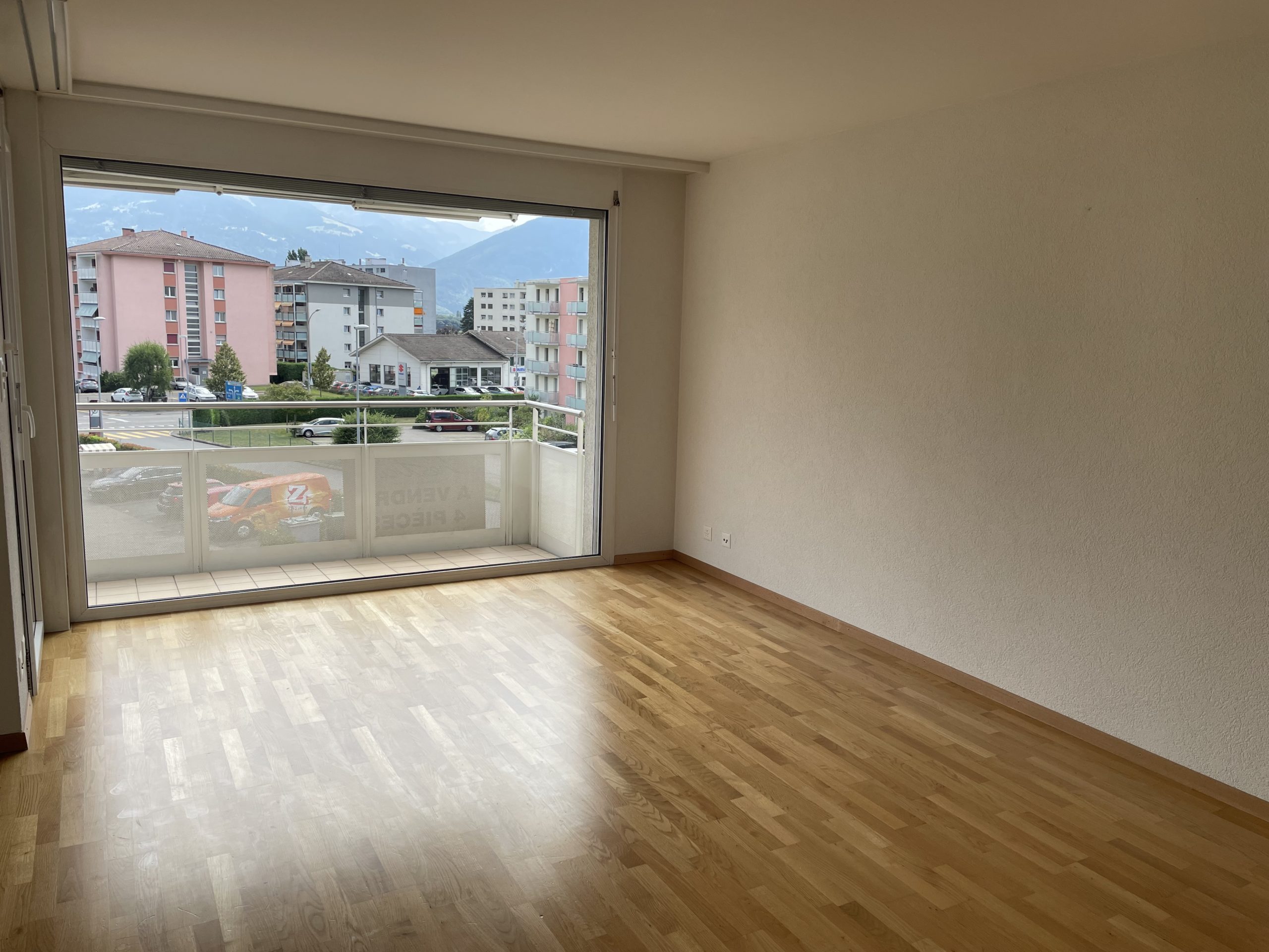 Leeres Wohnzimmer mit Balkon und Bergblick