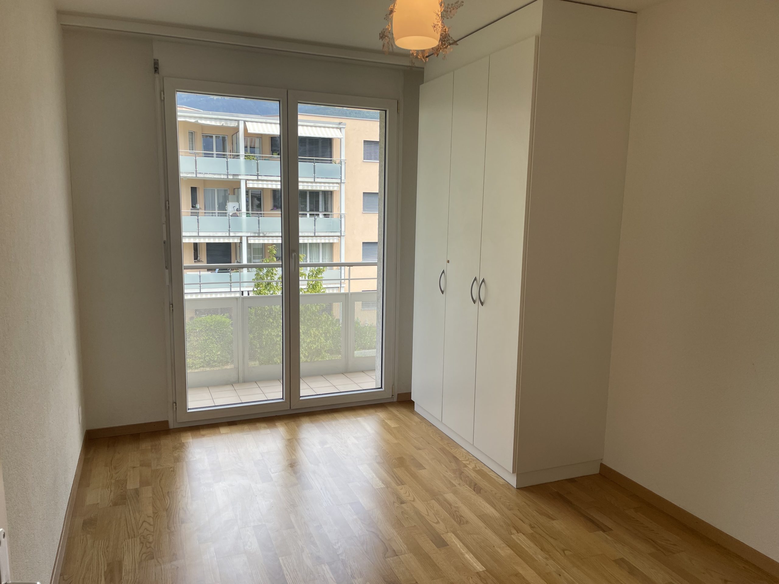 Helles, leeres Schlafzimmer mit Balkonblick
