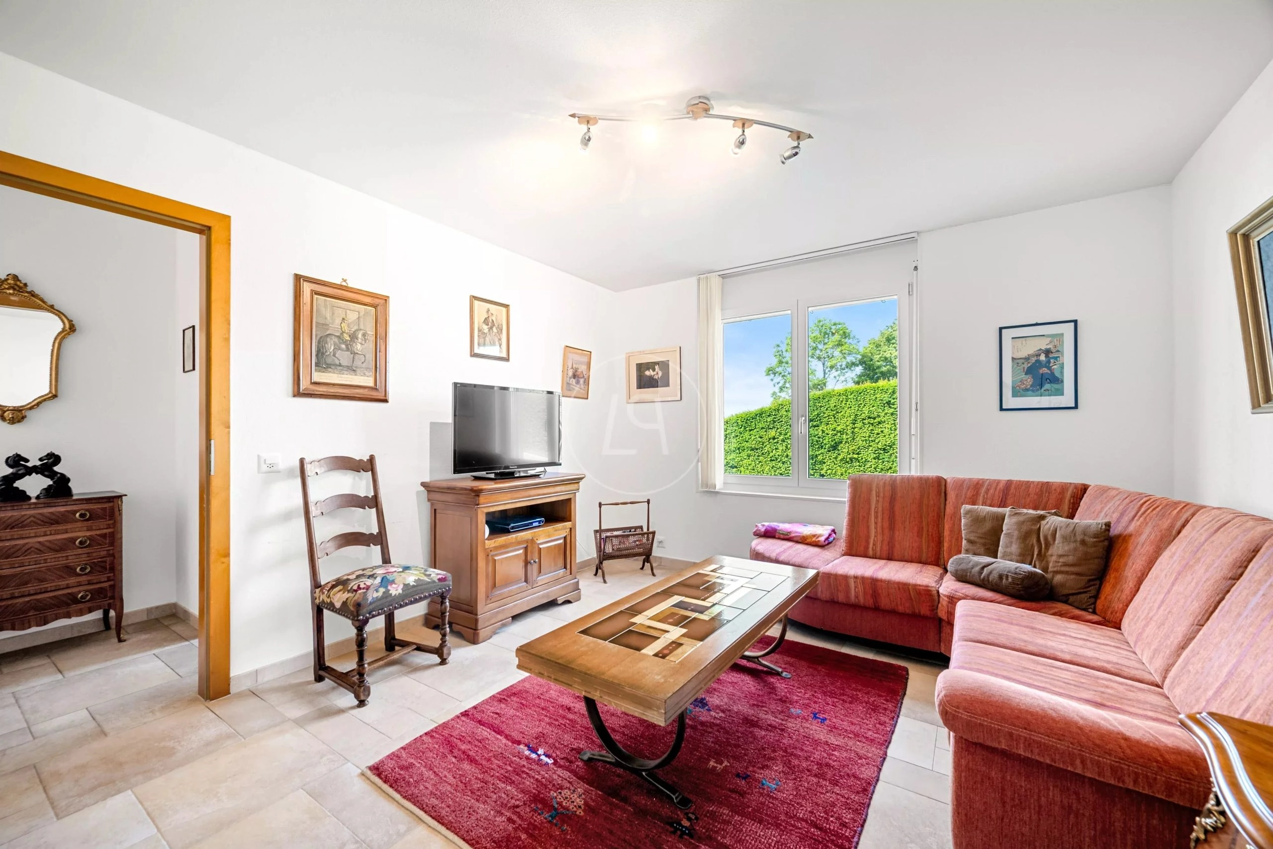 Wohnzimmer mit Fensterblick ins Grüne