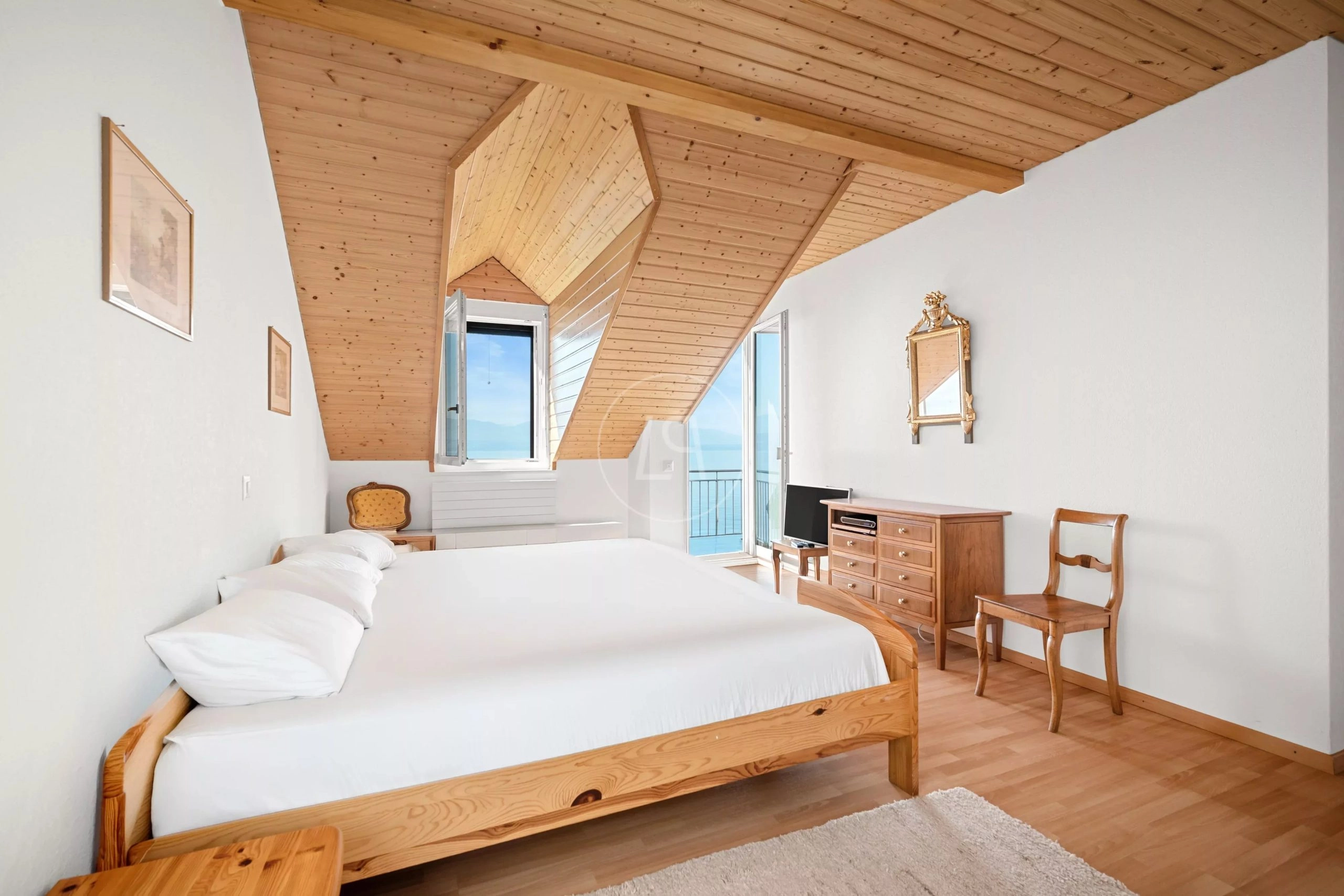 Helles Schlafzimmer mit Dachschrägen und Seeblick
